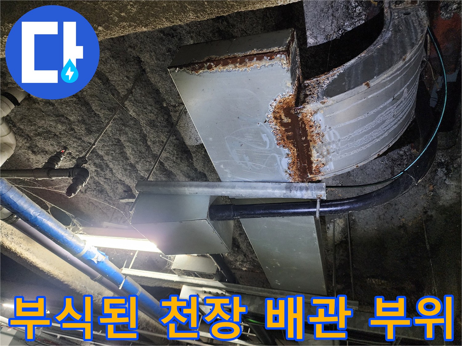 천장 안쪽 배관의 녹슨 연결 부위를 근접 촬영한 사진입니다.