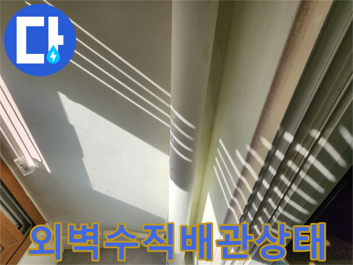 하얀색 수직 배관과 그 주변 벽면의 습기 상태를 보여주는 사진입니다.