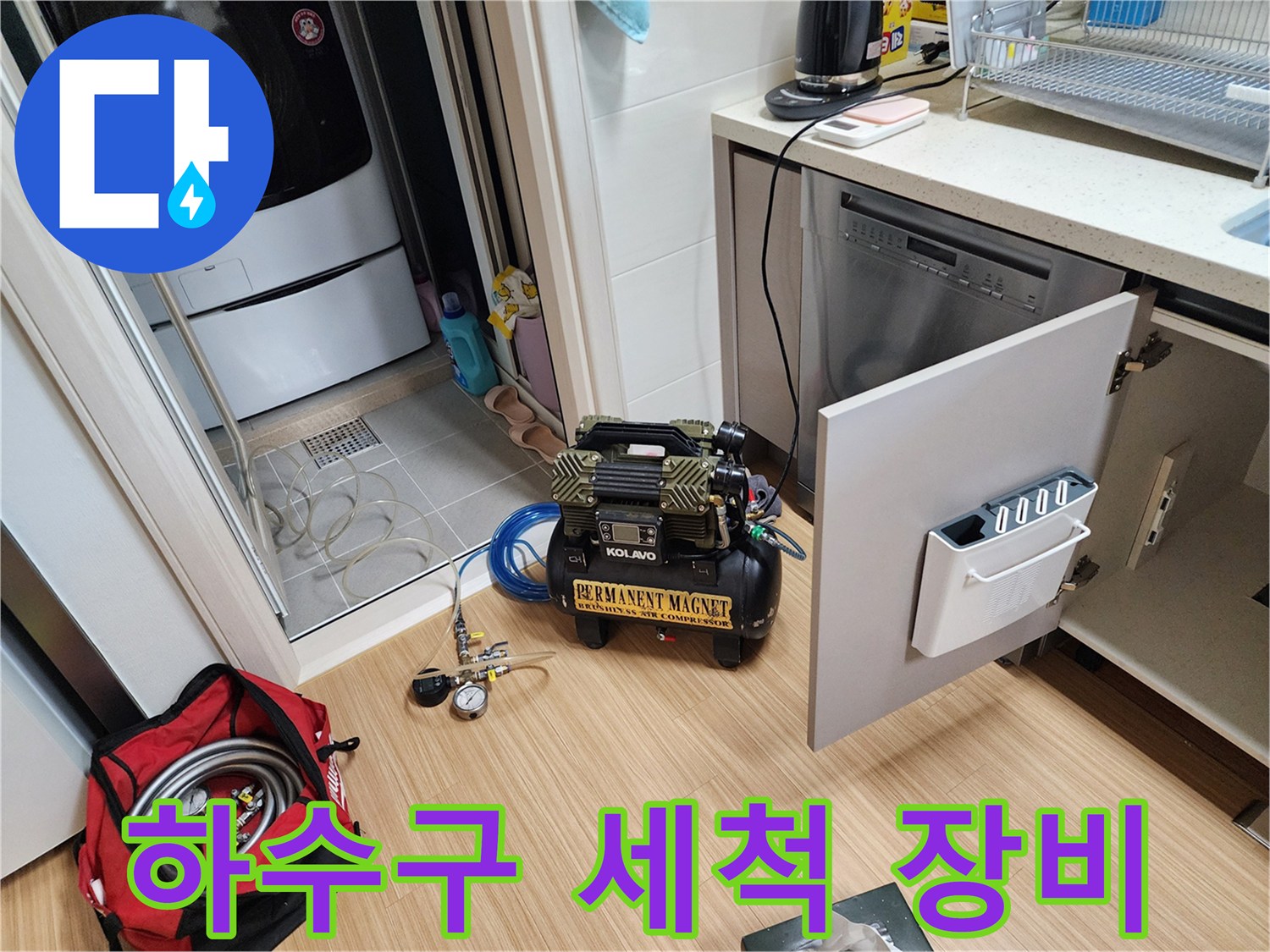 싱크대 하부 작업 공간에 놓인 - 배관 내부 세척용 전문 장비와 압력계