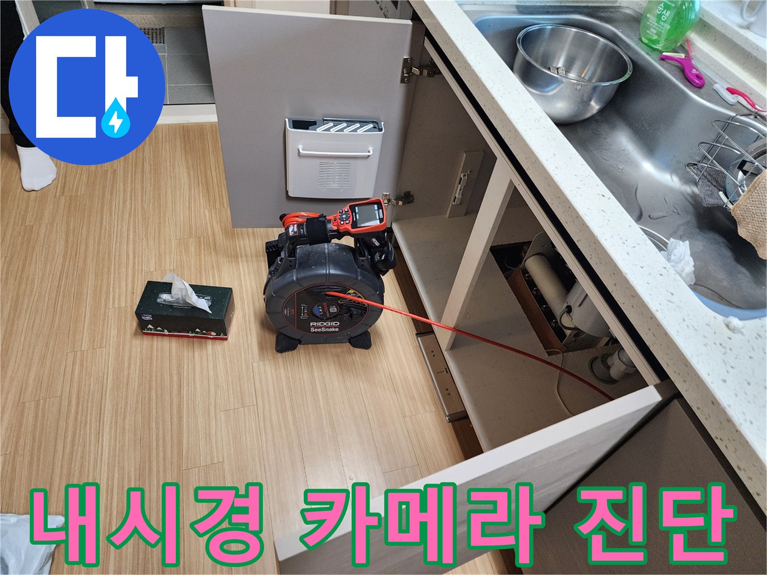 주방 싱크대 하부 배관 상태를 확인하기 위해 리지드 내시경 장비를 배치한 모습입니다.