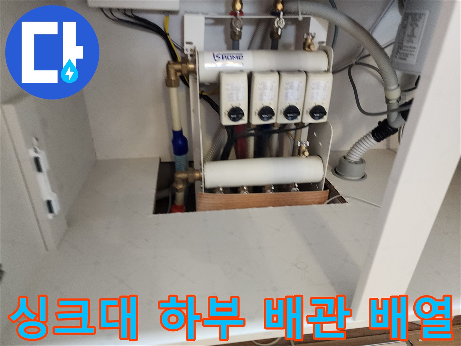 싱크대 하부장 내부의 난방 분배기와 연결된 각종 배관들입니다.