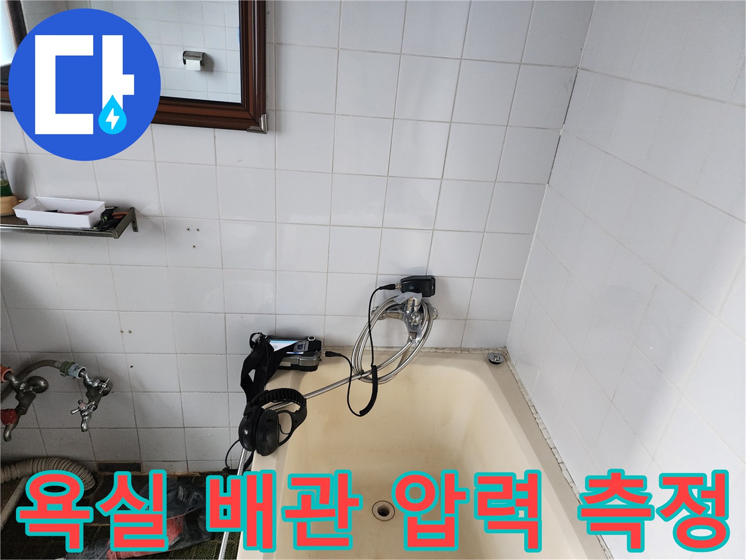 흰색 타일 벽면을 배경으로 배관 탐지 장비가 설치된 모습입니다.