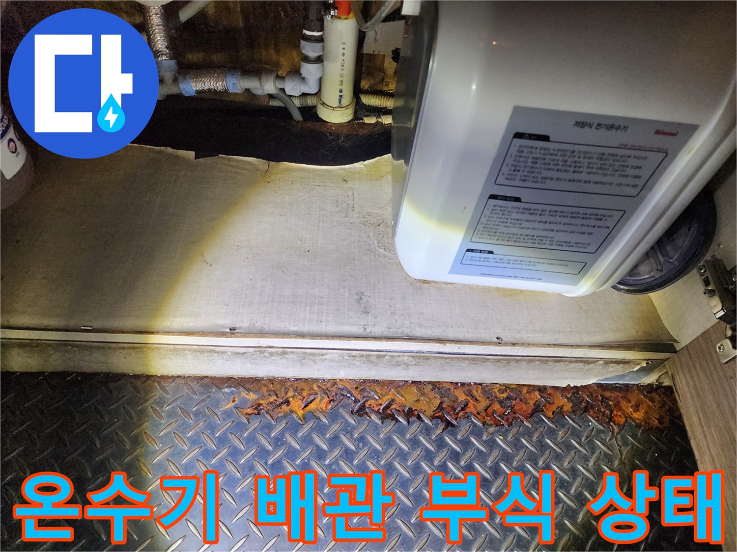 전기 온수기 하단 배관 연결 부위의 심한 부식과 누수 흔적