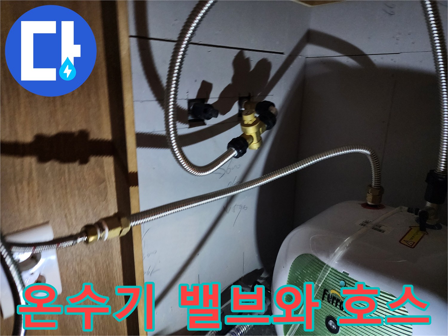 벽면 금속 밸브와 온수기를 연결하는 유연한 배관 부위