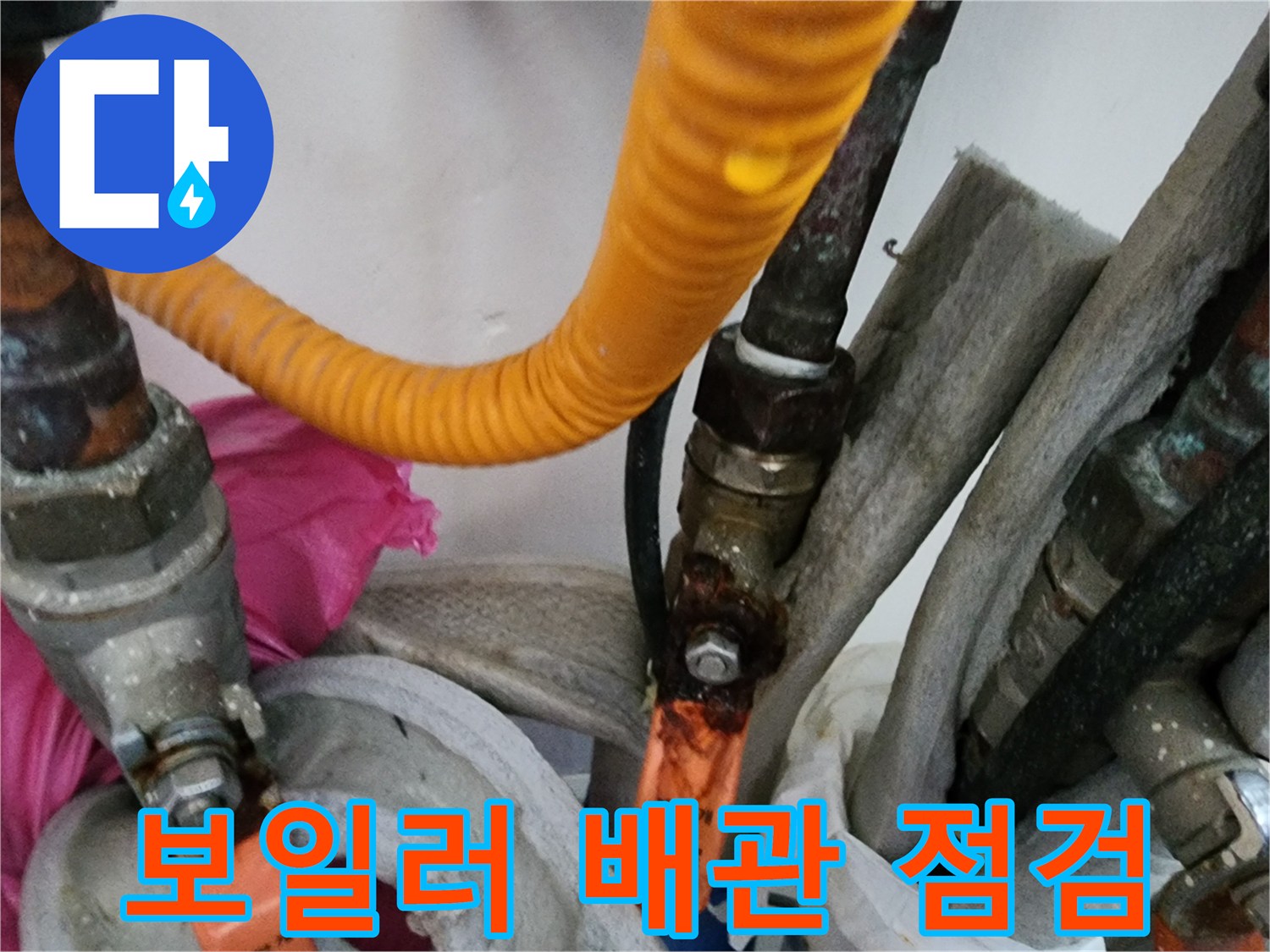 노란색 보온재가 씌워진 배관과 금속 부속의 연결 상태를 근접 촬영한 사진입니다.