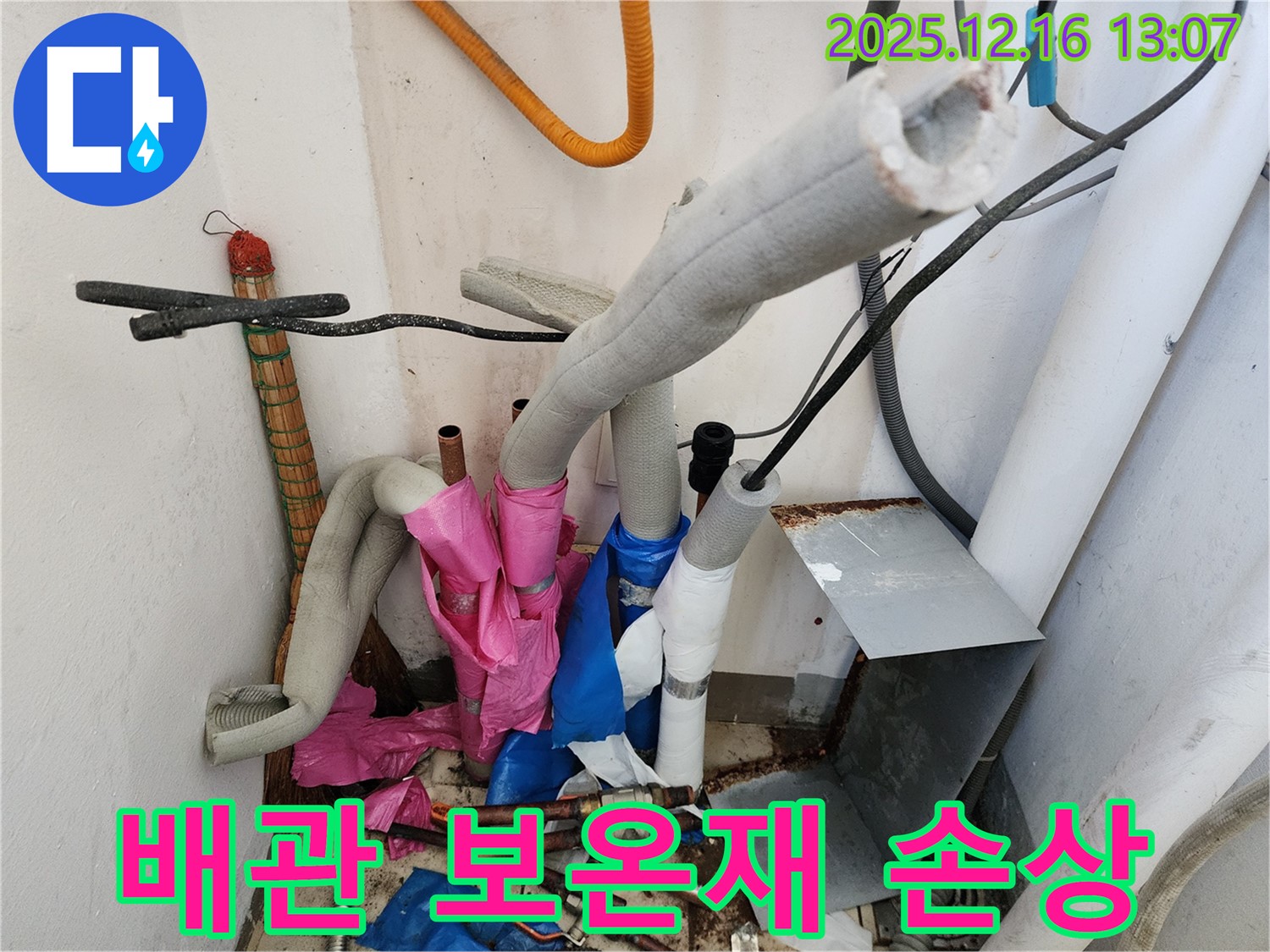 손상된 보온재 - 배관을 감싸고 있는 보온재가 손상되어 누수가 발생한 부분을 보여주는 사진입니다.