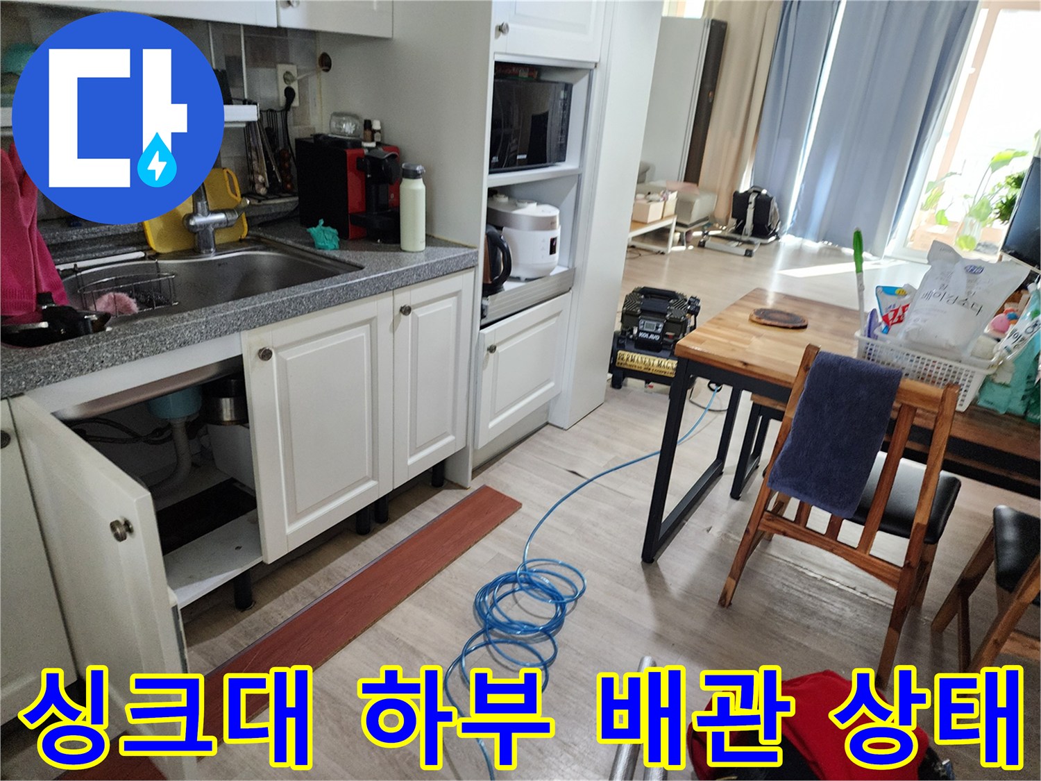 싱크대 하부장 내부의 복잡한 배관과 주변 공간 사진