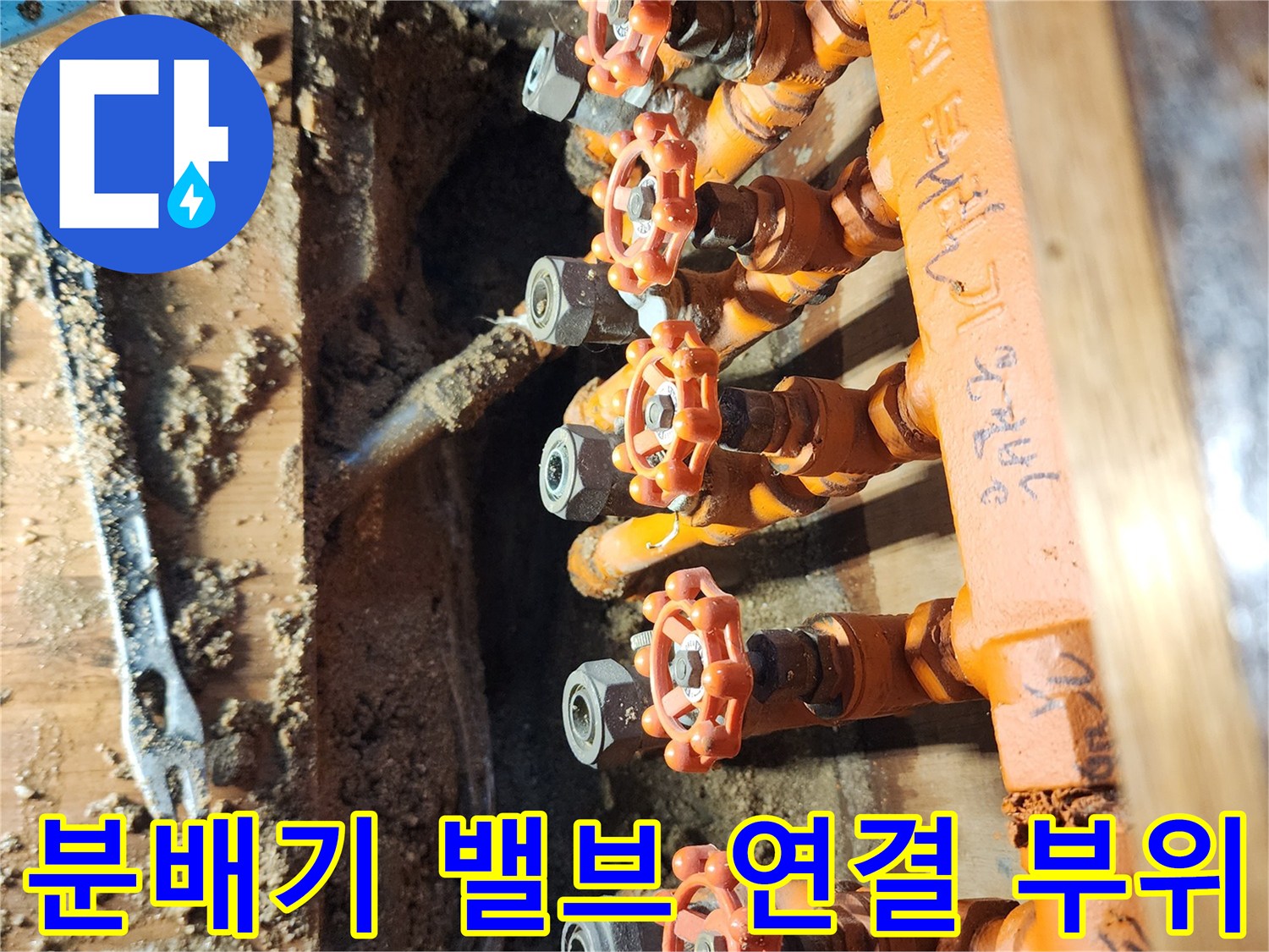 오렌지색 보온재와 분배기 밸브가 보이는 현장 사진입니다.
