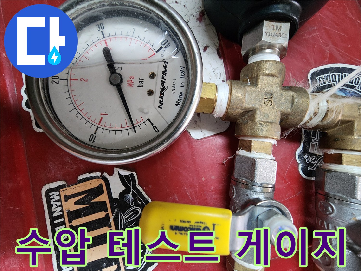 분배기 배관에 연결된 압력계와 노란색 조절 밸브의 모습