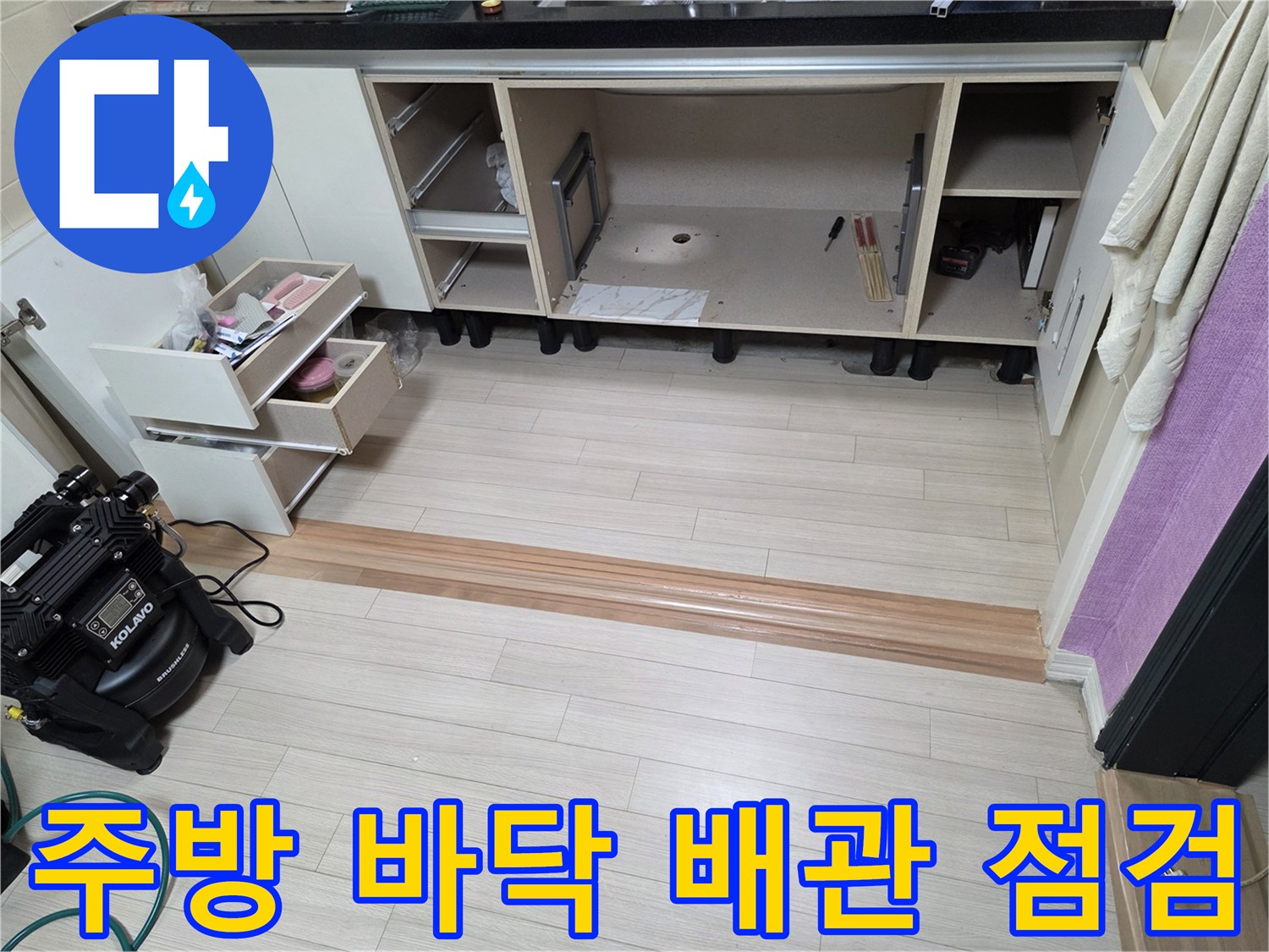 싱크대 하단 서랍을 모두 분리하여 노출시킨 주방 바닥과 탐지 장비의 모습입니다.