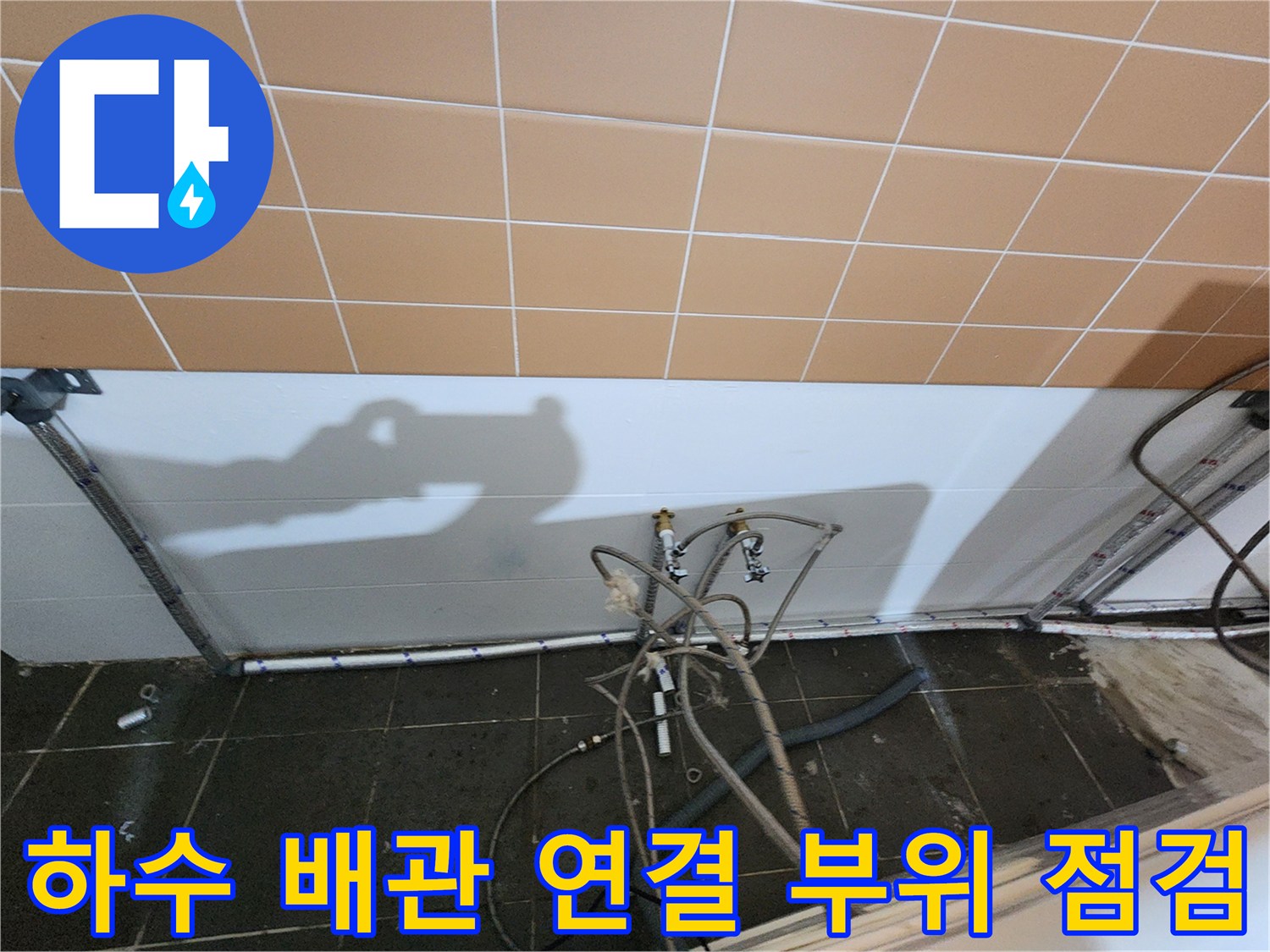 미용실 샴푸대 하단에 노출된 배관과 타일 벽면 모습