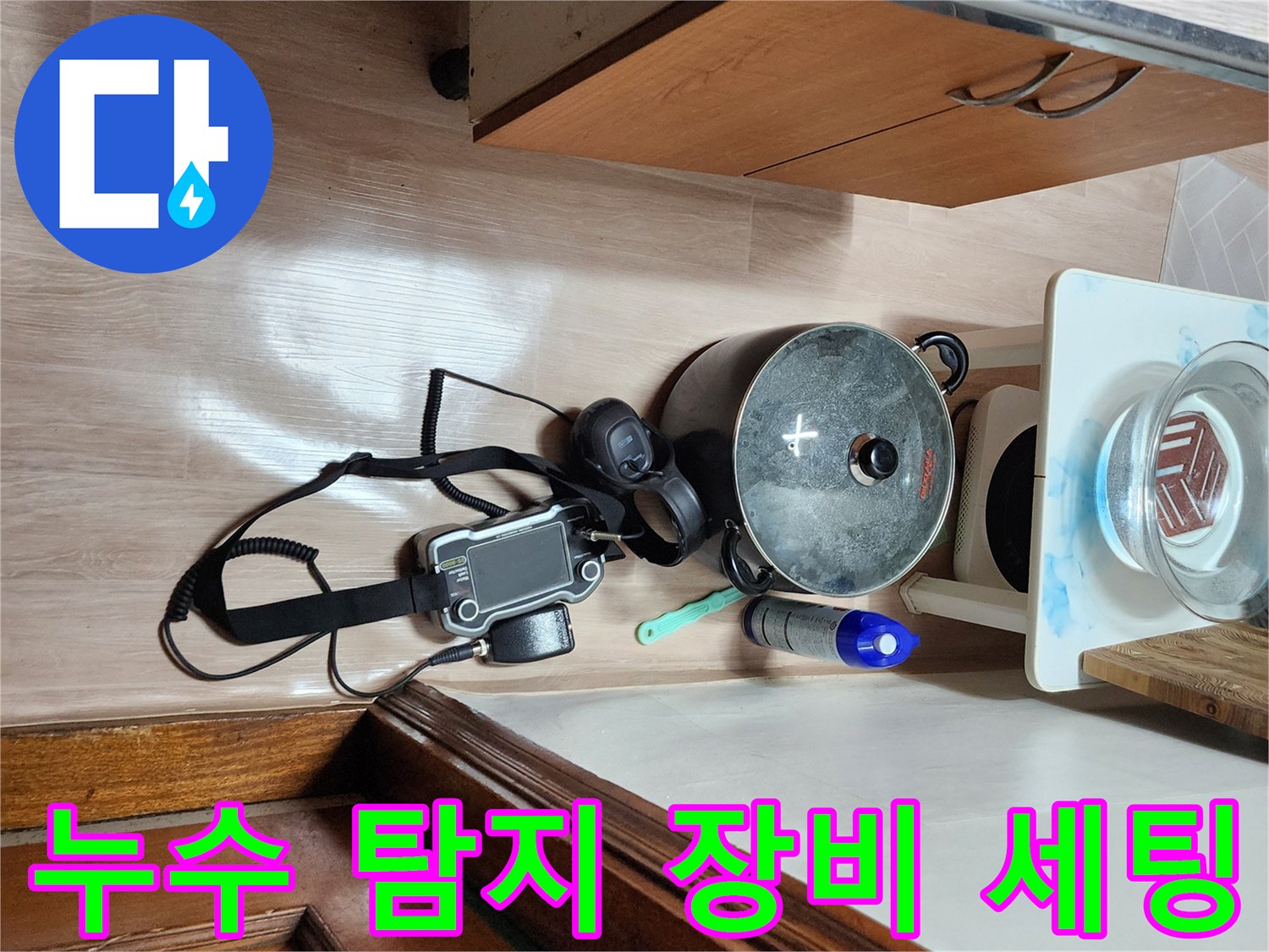 주방 가구 주변에 배치된 누수 탐지용 가스 측정기와 청음 장비입니다.