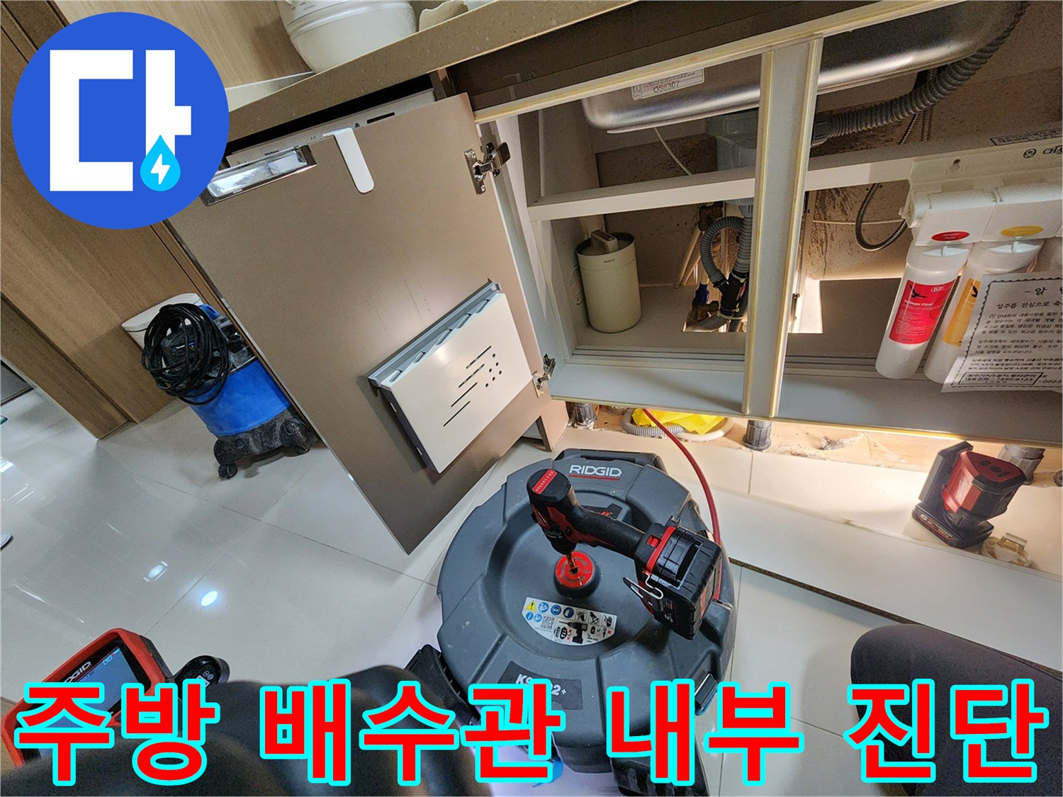 싱크대 아래쪽 배관 부근에 내시연 장비를 배치하여 점검하는 장면입니다.