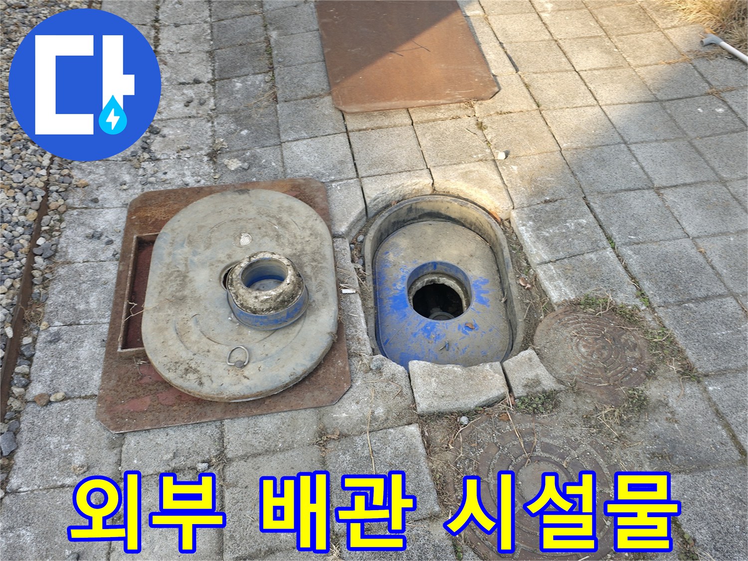 건물 외부-계량기함과 주변 맨홀 덮개 근처 작업지점