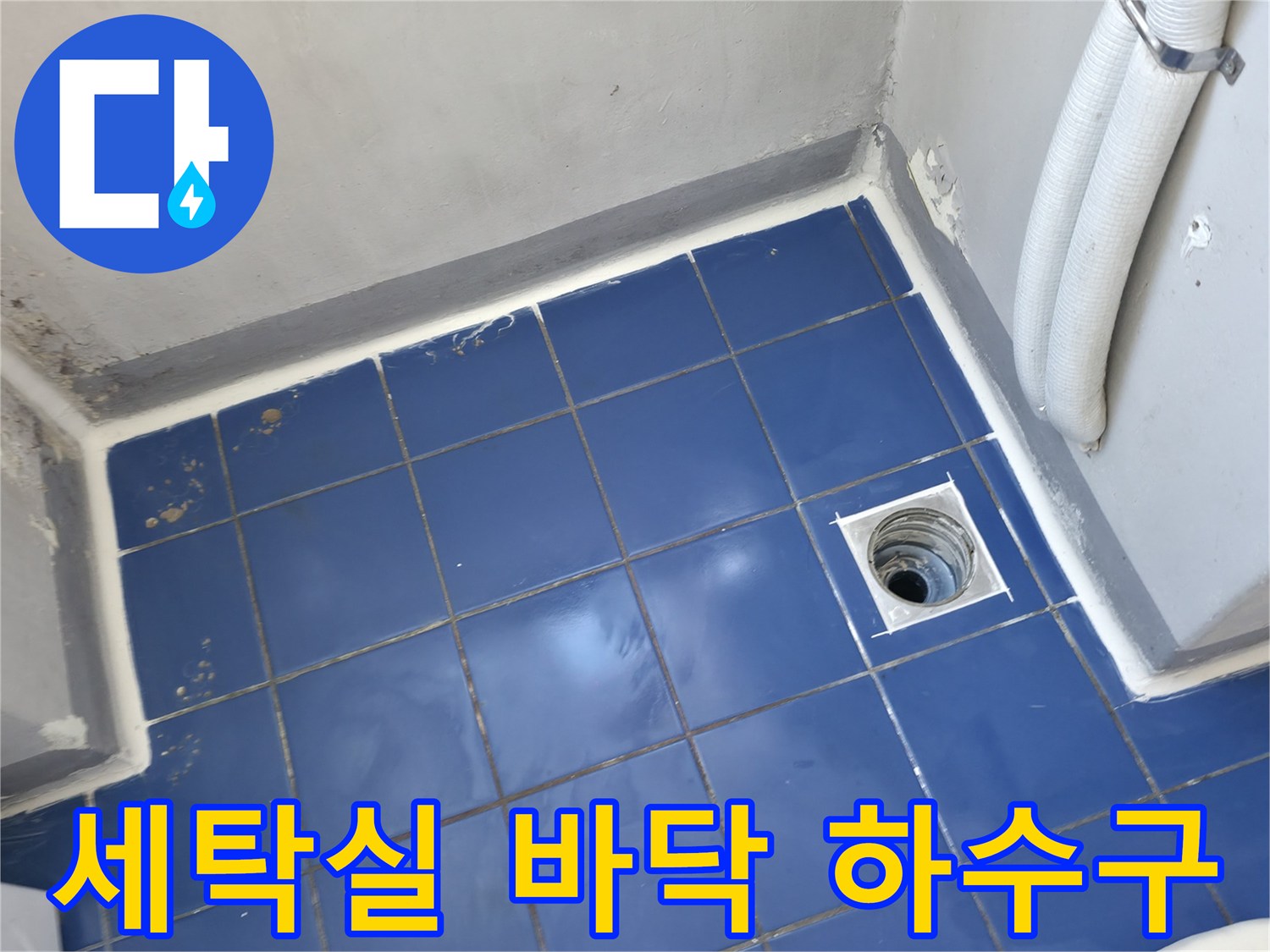파란색 타일 바닥에 위치한 흰색 배수구 입구 모습