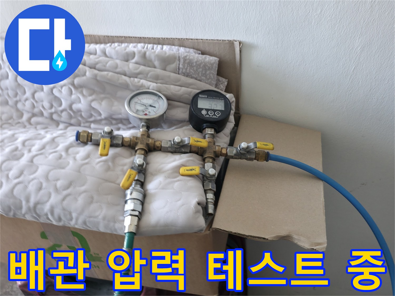 수도 배관의 기밀 상태를 확인하기 위해 공압계와 게이지를 연결한 모습입니다.