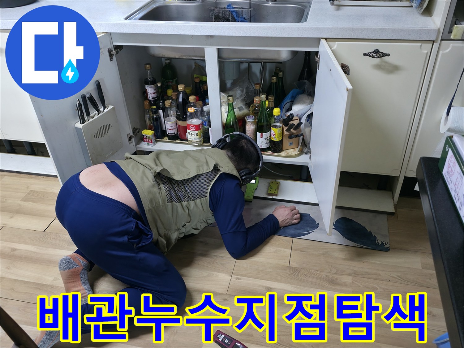 싱크대 하부장 안쪽 배관 라인을 따라 누수 지점을 추적하고 있습니다.