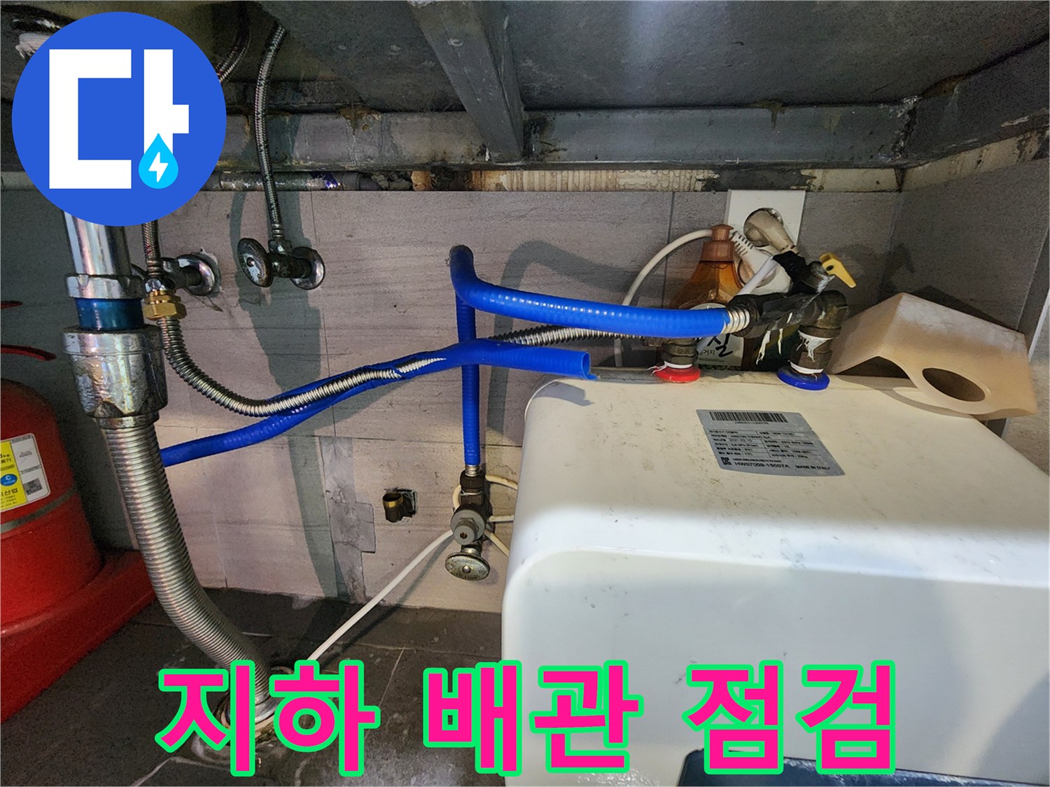 파란색 호스가 연결된 흰색 탱크와 금속 배관 부위
