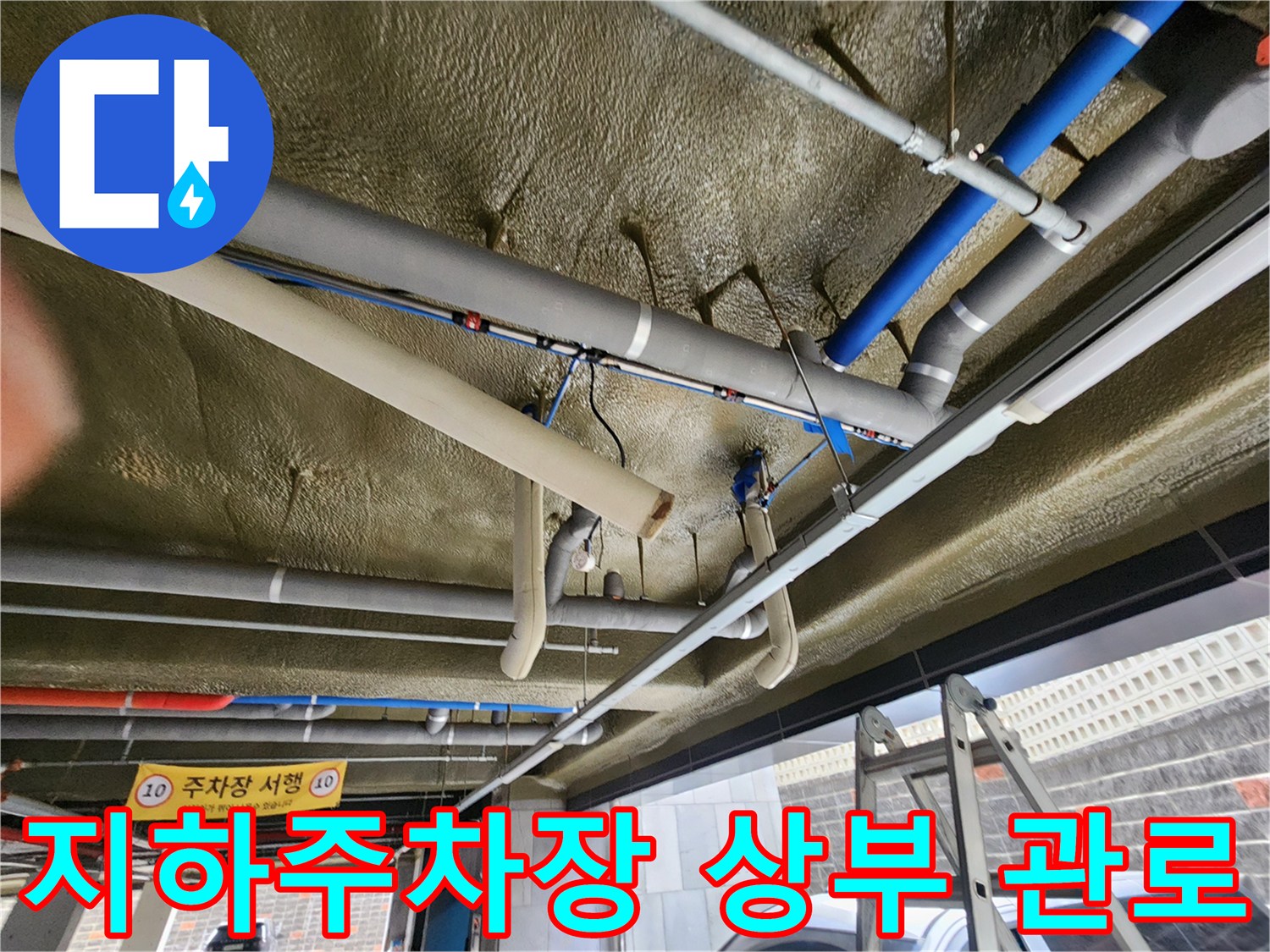 지하주차장 천장에 설치된 여러 갈래의 급수 및 배수 배관