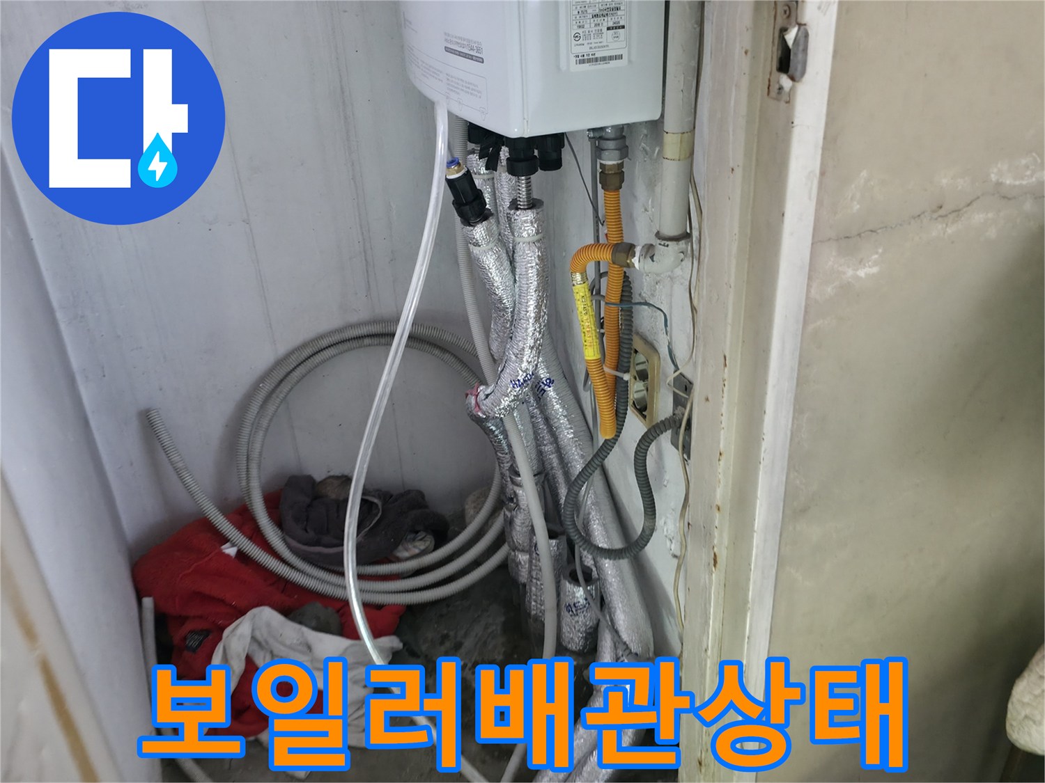 보일러 하단에 연결된 여러 갈래의 배관과 보온재 사진