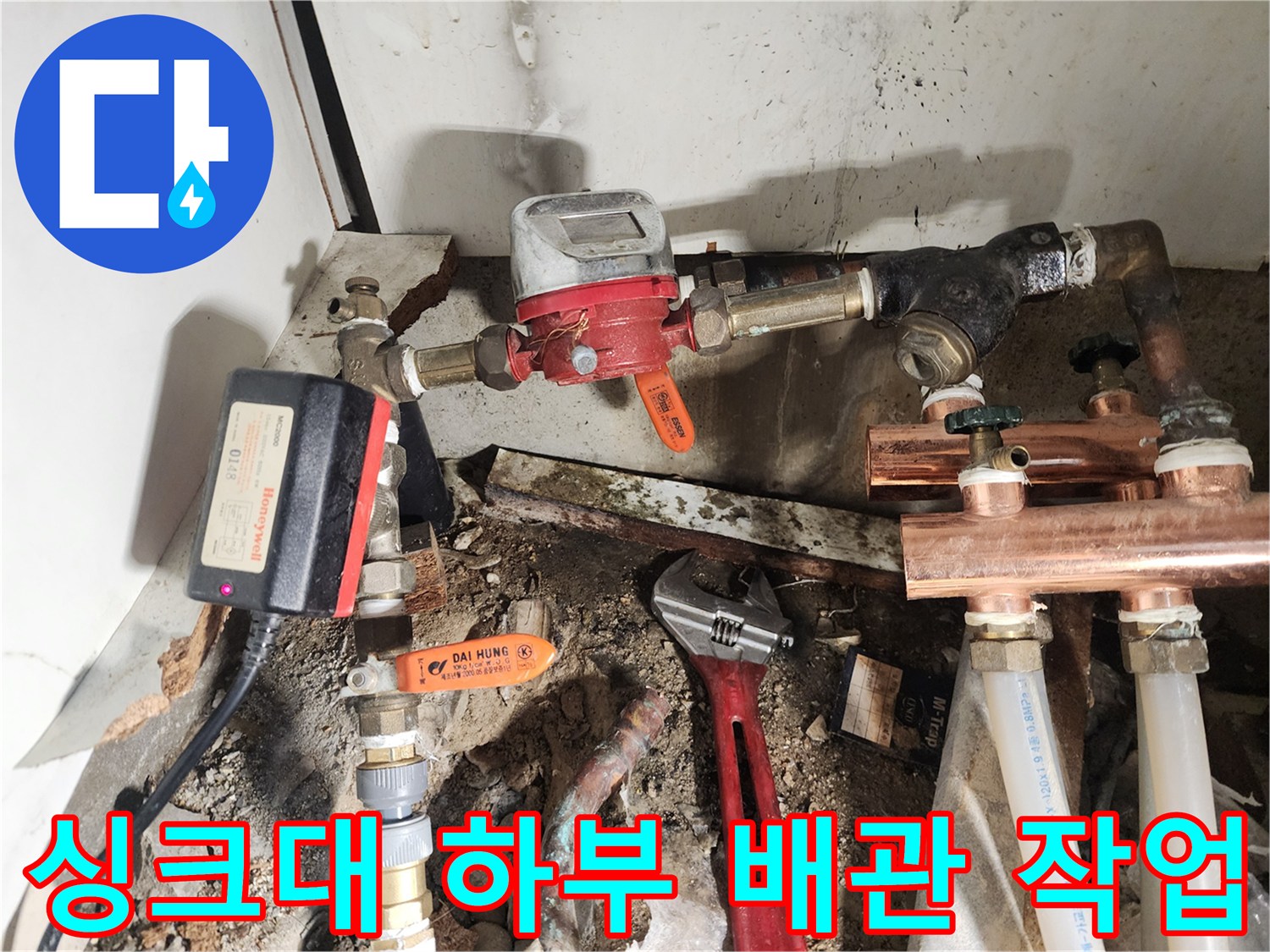 싱크대 아래 복잡한 수도 배관과 밸브 교체 작업 현장