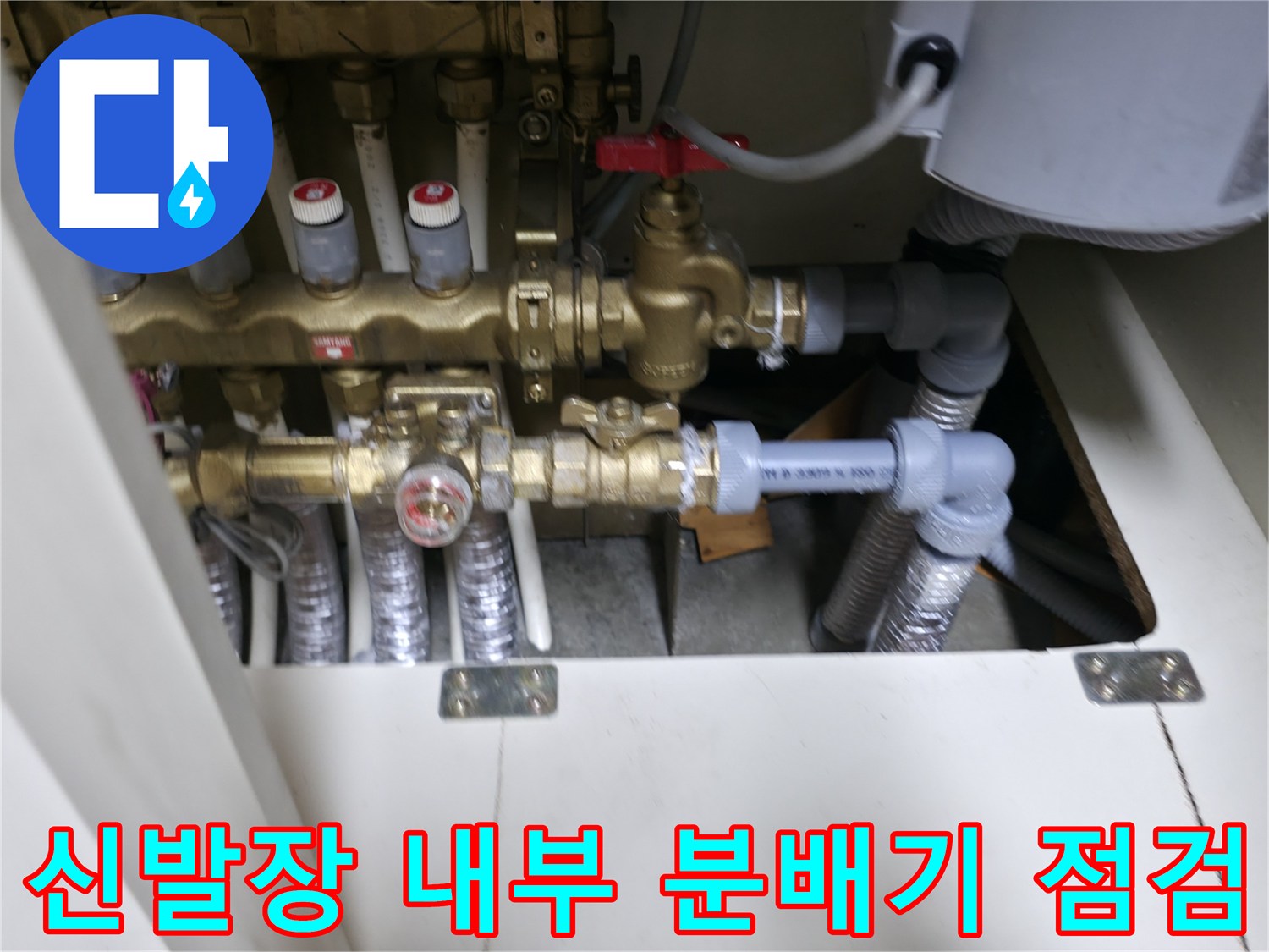 신발장 내부에 위치한 이중배관 분배기와 연결 부위의 상태를 확인하는 모습입니다.