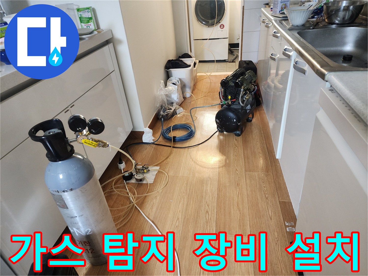 누수 지점을 찾기 위해 주방 바닥에 배치된 가스통과 호스 연결 상태