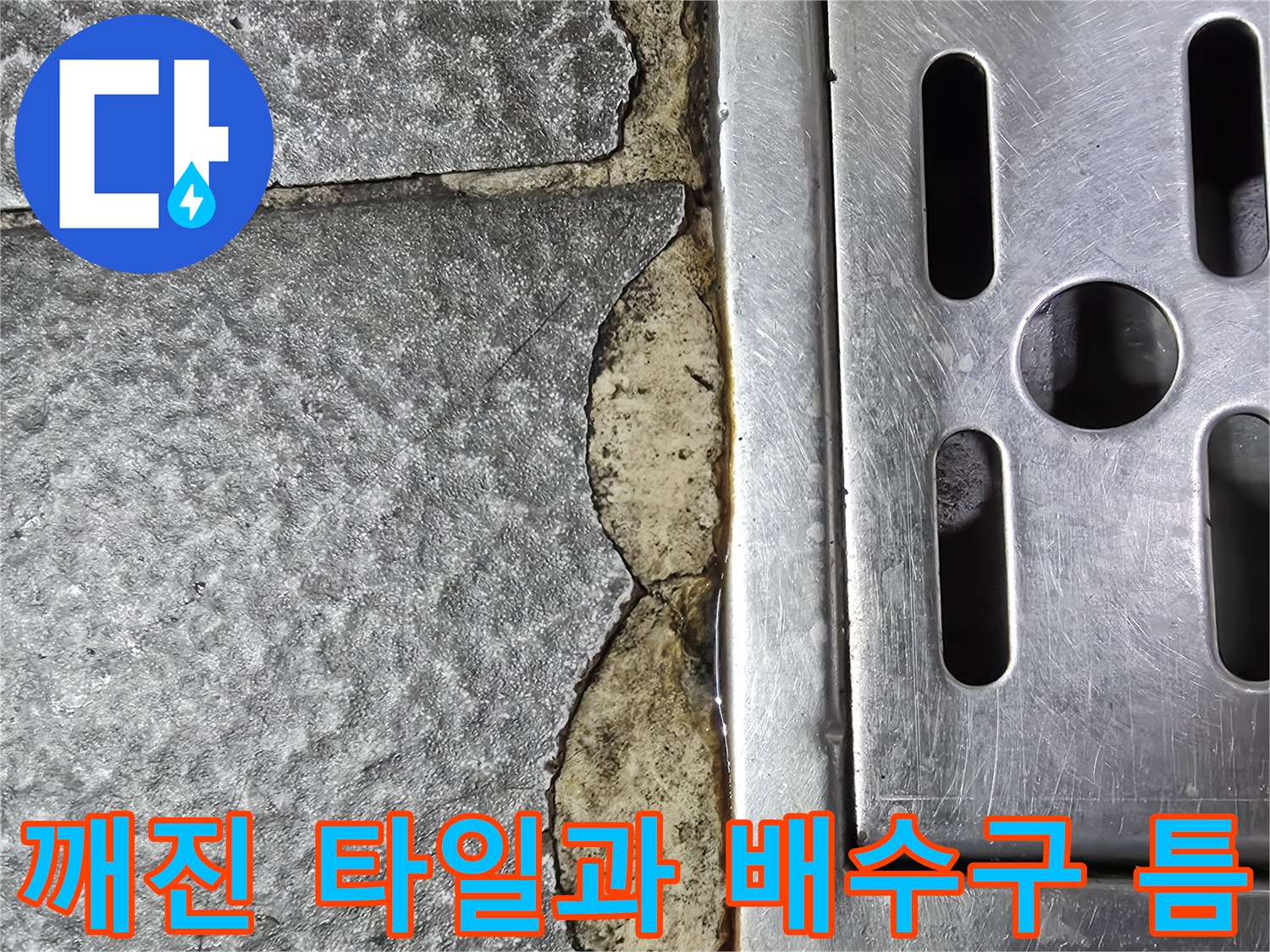 배수구 주변의 타일이 깨지고 메지가 유실된 현장 사진입니다.