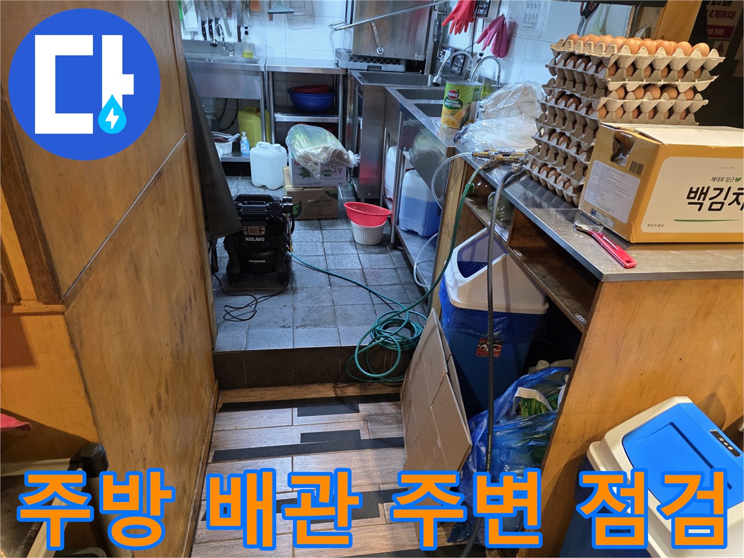 식당 주방 배관 연결 부위와 바닥 타일 상태를 촬영한 모습