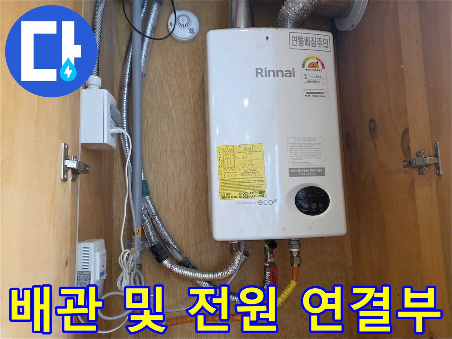 온수기 하단 배관과 전기 플러그가 꽂힌 콘센트 모습