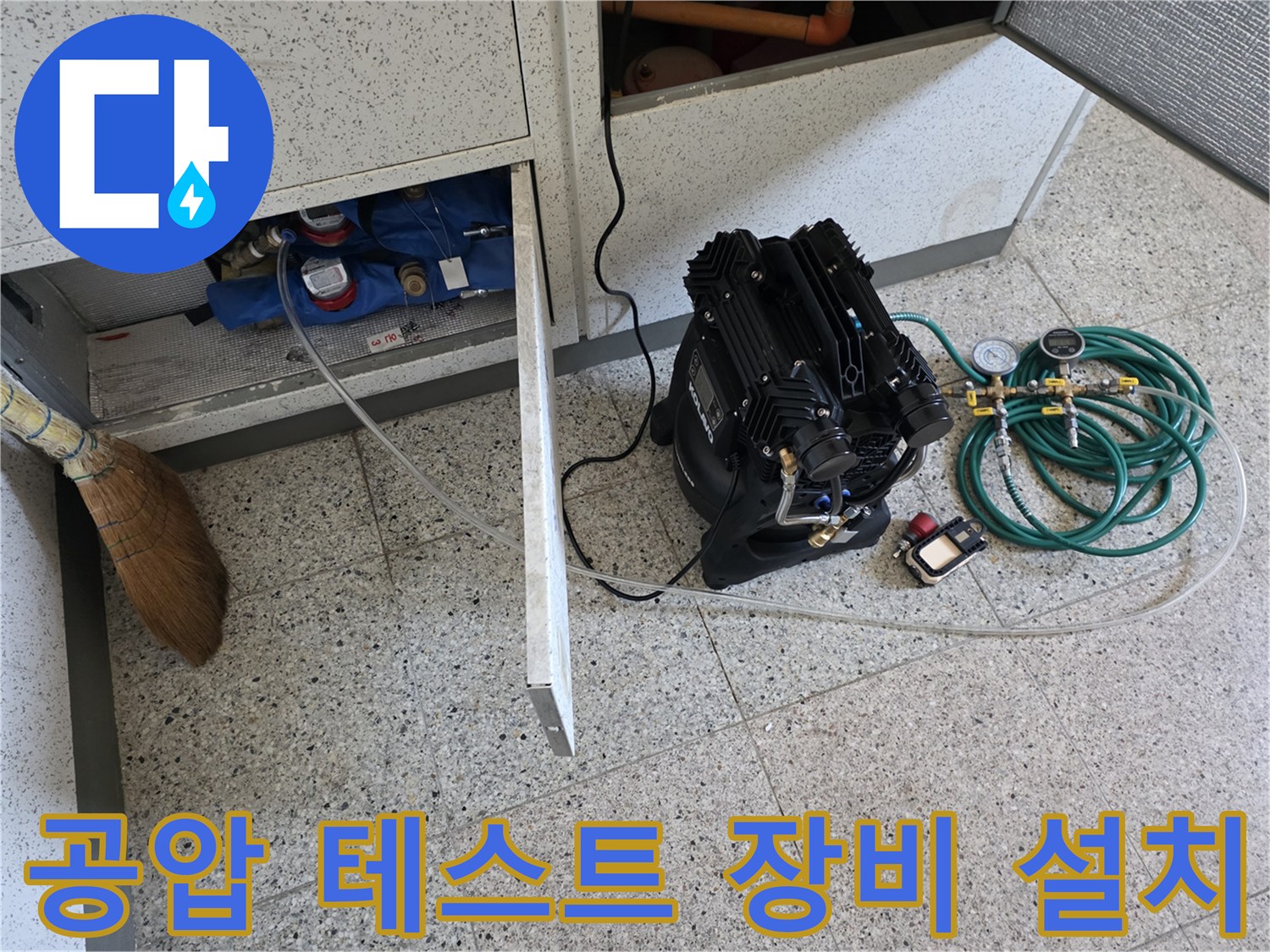 싱크대 하단 배관 점검을 위해 설치된 공압 테스트 장비와 압력계