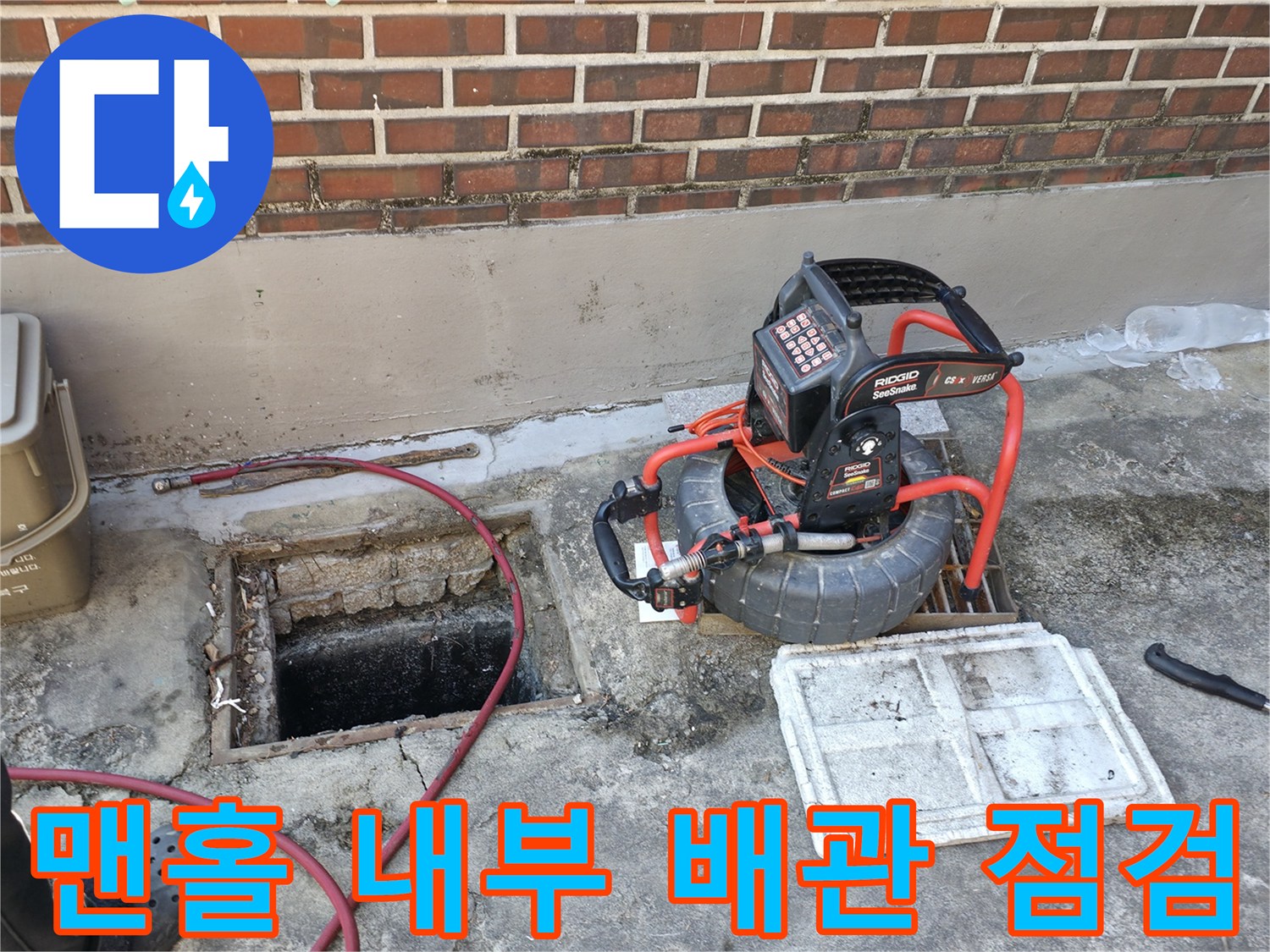 열려 있는 맨홀과 그 주변에 놓인 하수관 세척용 장비들