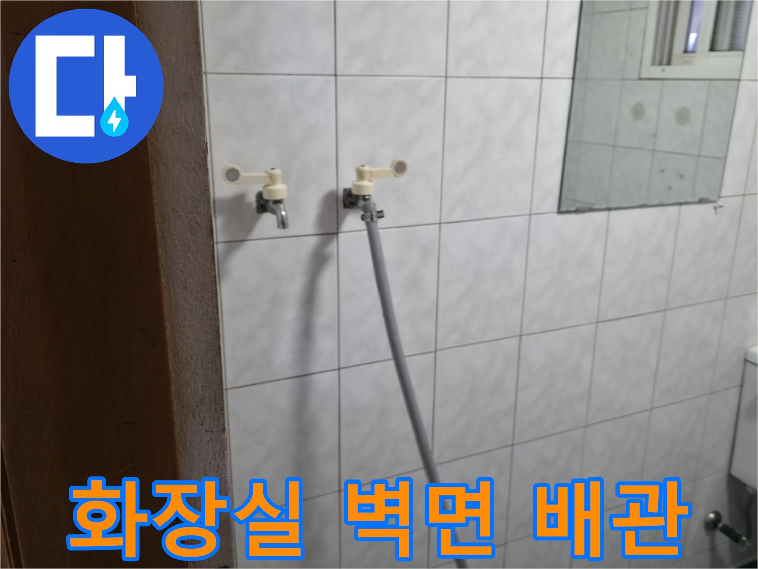 화장실-벽면에-설치된-급수용-밸브와-호스-연결부