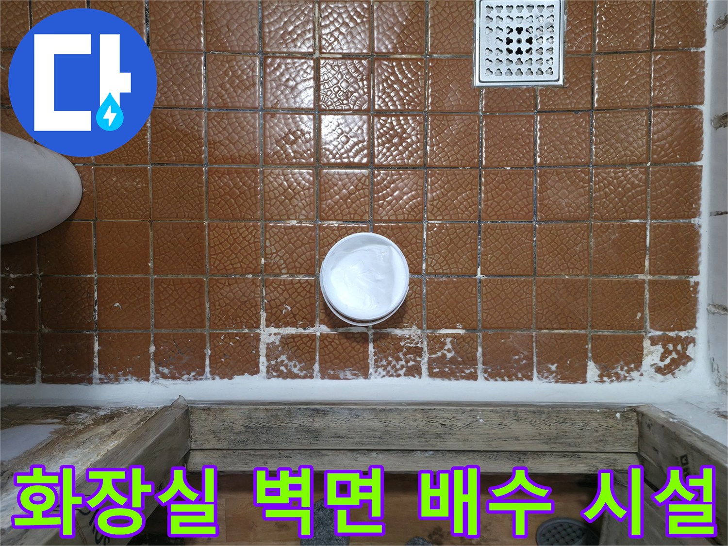 욕실 내부 상세-갈색 타일과 흰색 배수구 구조물