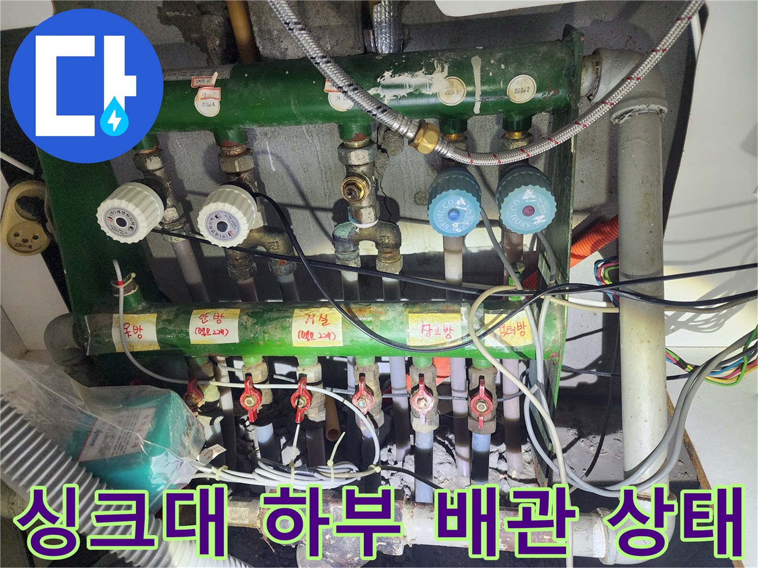 싱크대 아래 분배기와 여러 개의 밸브가 복잡하게 연결된 배관 구조를 보여줍니다.