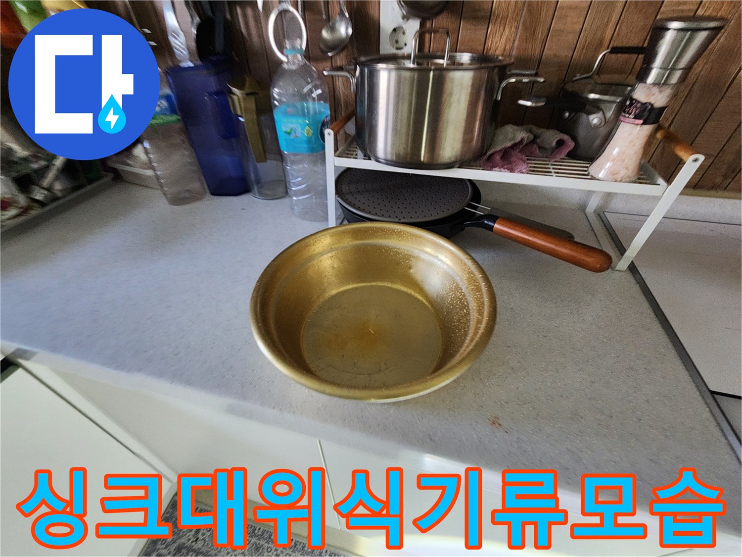 주방 조리대 위에 정리된 스테인리스 냄비와 금색 볼