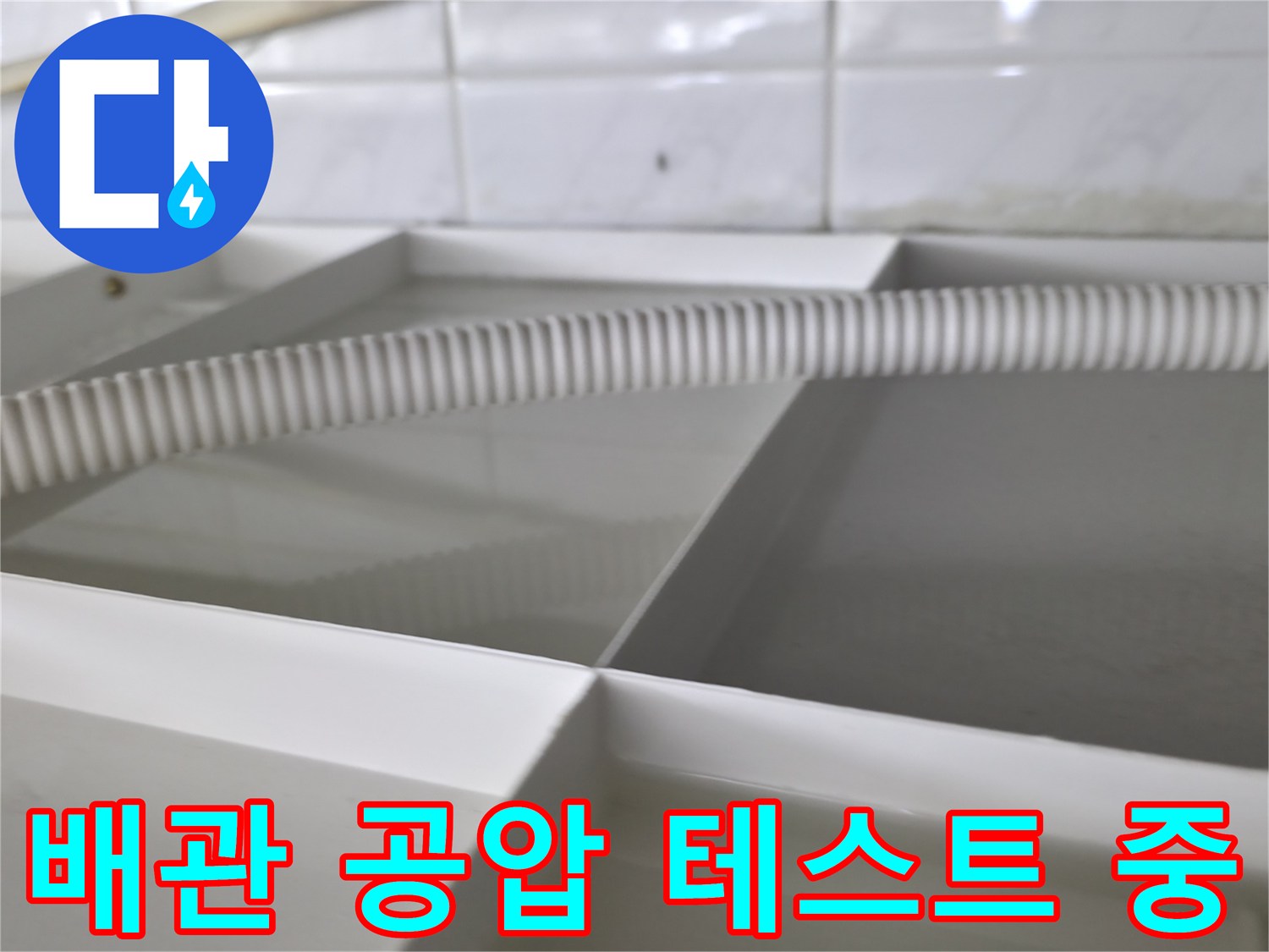 화장실 배관의 기밀성을 확인하기 위해 호스를 연결하여 공압 테스트를 진행하는 모습입니다.