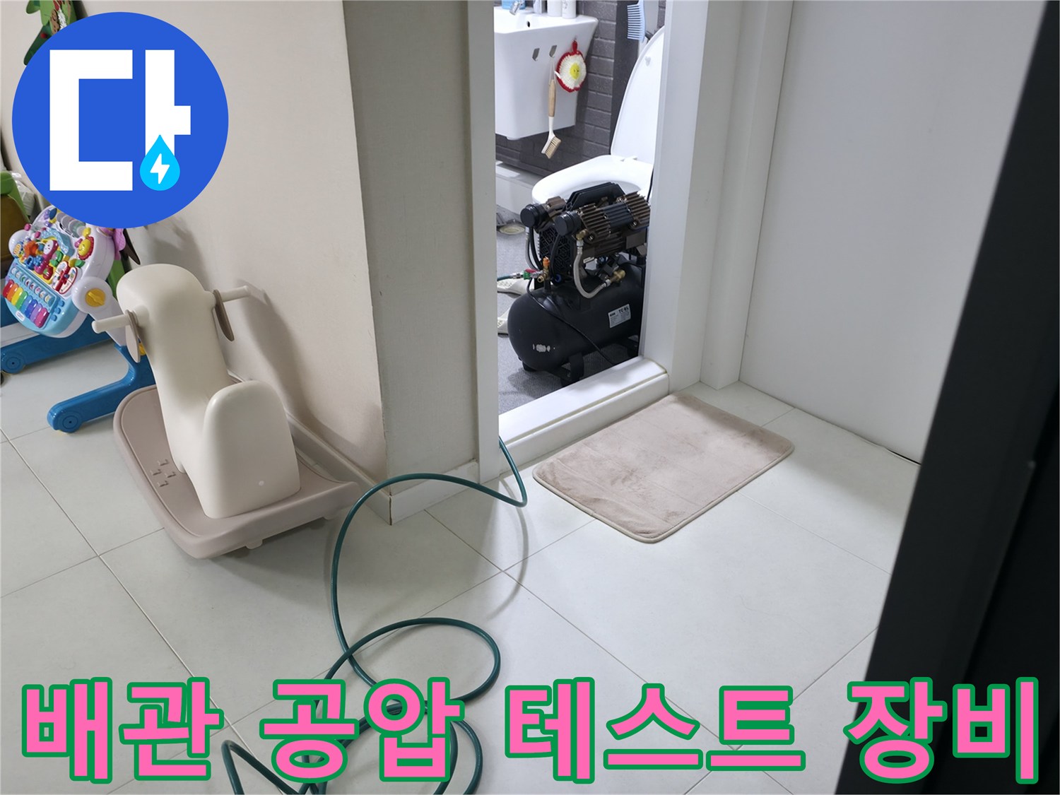 화장실 입구에 설치된-배관 압력 점검을 위한-공압 테스트 장비와 호스