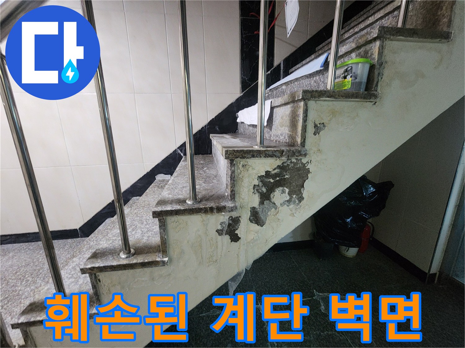 계단 하단부 벽면-물샘으로 인해 부스러진 시멘트와 얼룩