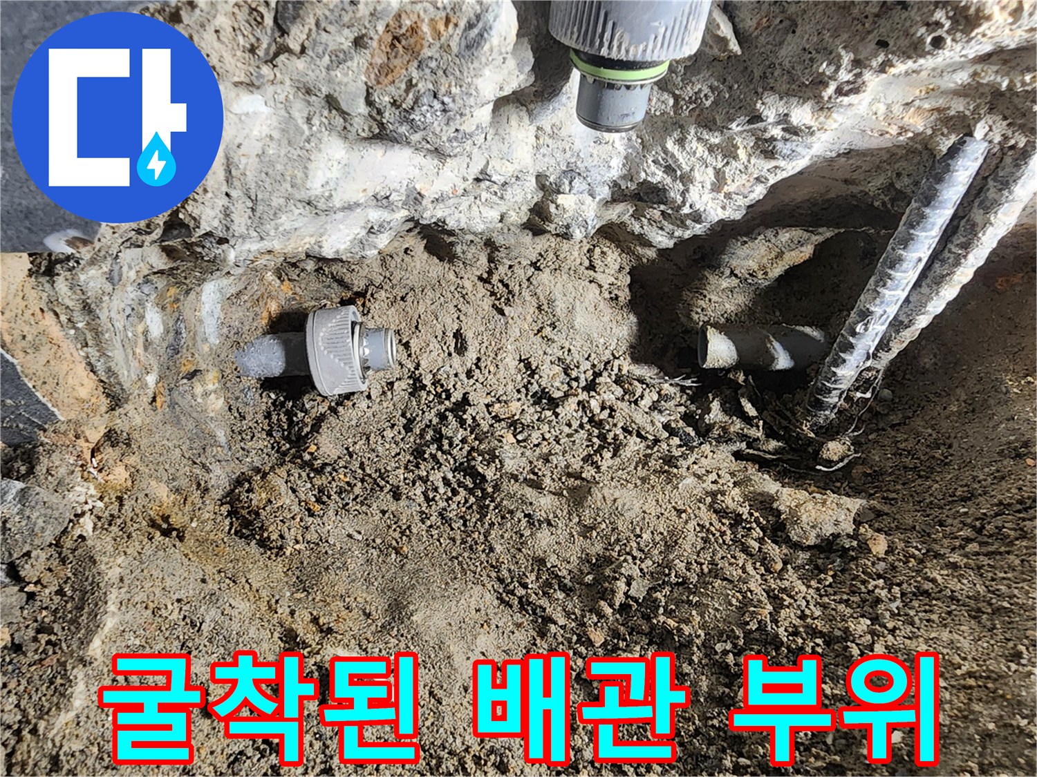 시멘트 층을 제거하여 드러난 수도 연결 배관과 주변 흙