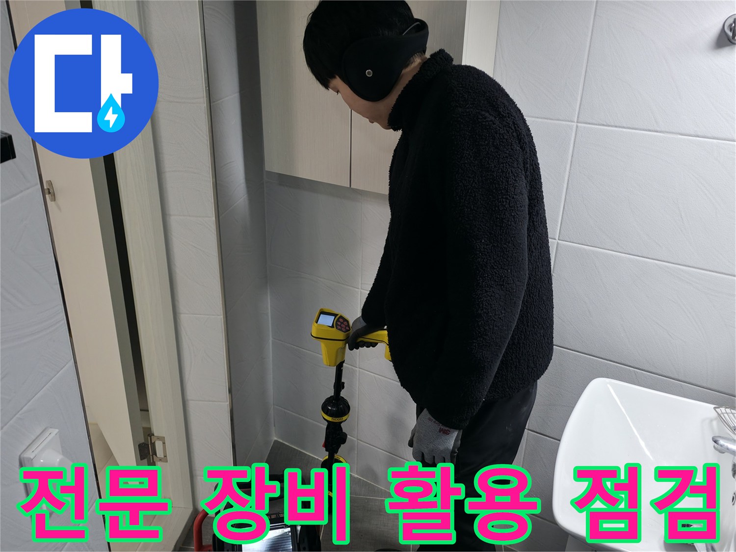화장실 내부에서 전문 탐지 기기를 사용하여 배관의 이상 여부를 정밀하게 파악하는 장면