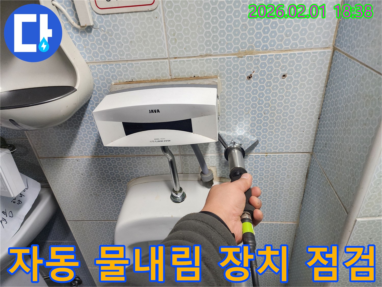 소변기 자동 물내림 장치의 작동 상태를 점검하는 모습 - 꼼꼼한 점검으로 문제 원인을 파악합니다.