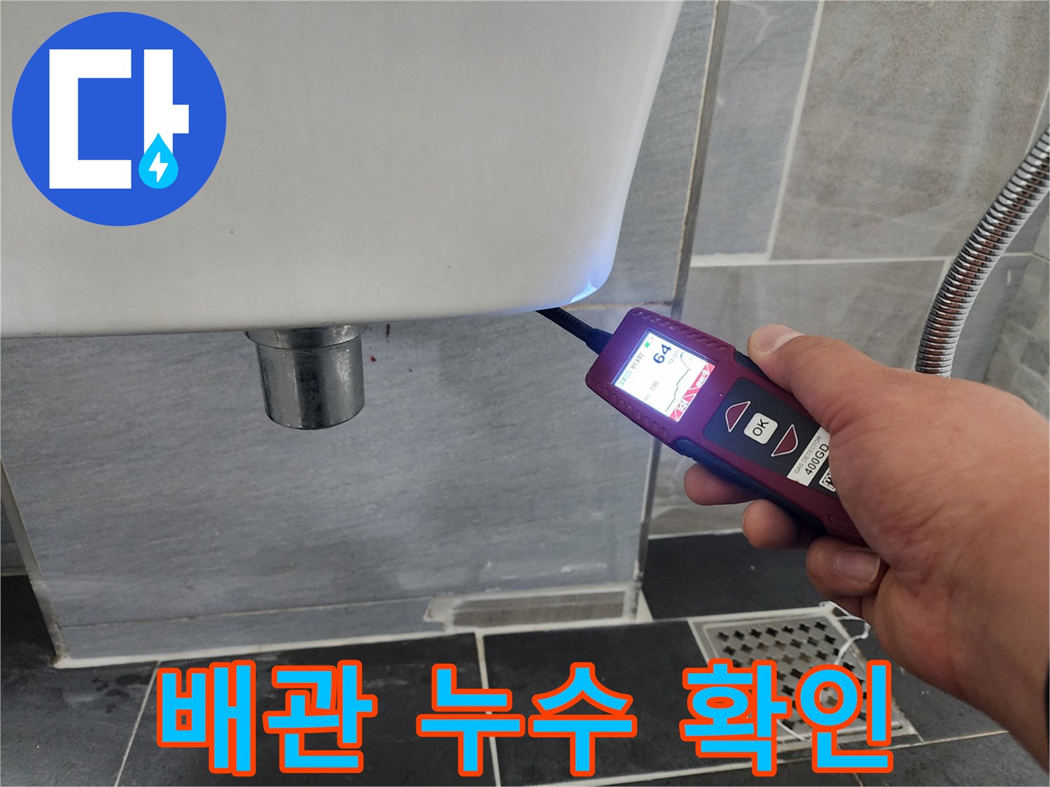 변기 근처 타일 벽면의 수분 함량을 탐지기로 측정하는 모습