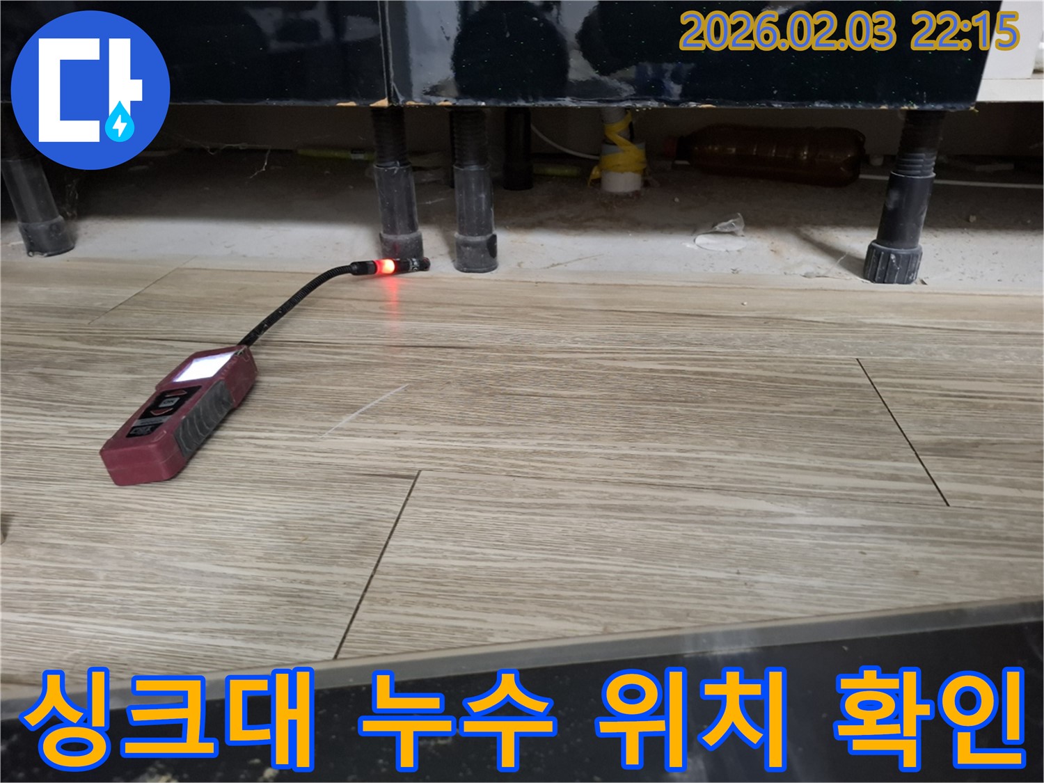싱크대 아래에서 누수 탐지 장비로 누수 위치를 확인하는 모습 - 어두운 곳도 문제없이 찾아냅니다.