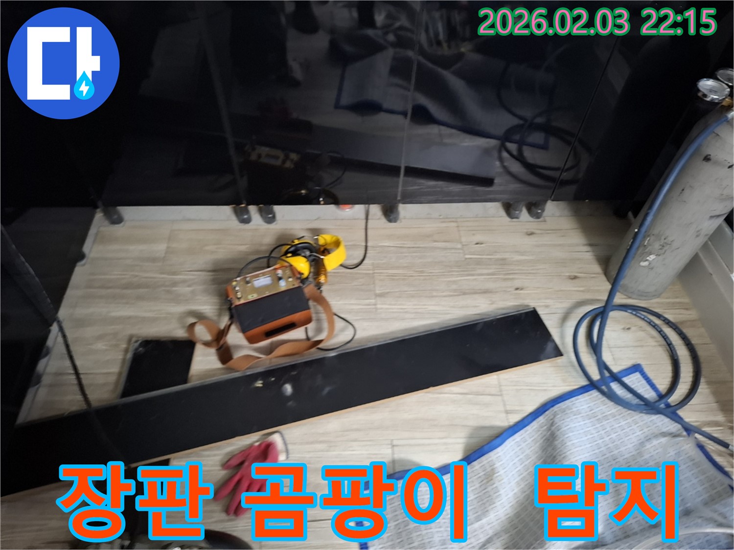 첨단 누수 탐지 장비를 사용하여 장판 아래 곰팡이의 원인인 누수를 찾아내는 모습 - 곰팡이 제거와 누수 해결을 동시에!