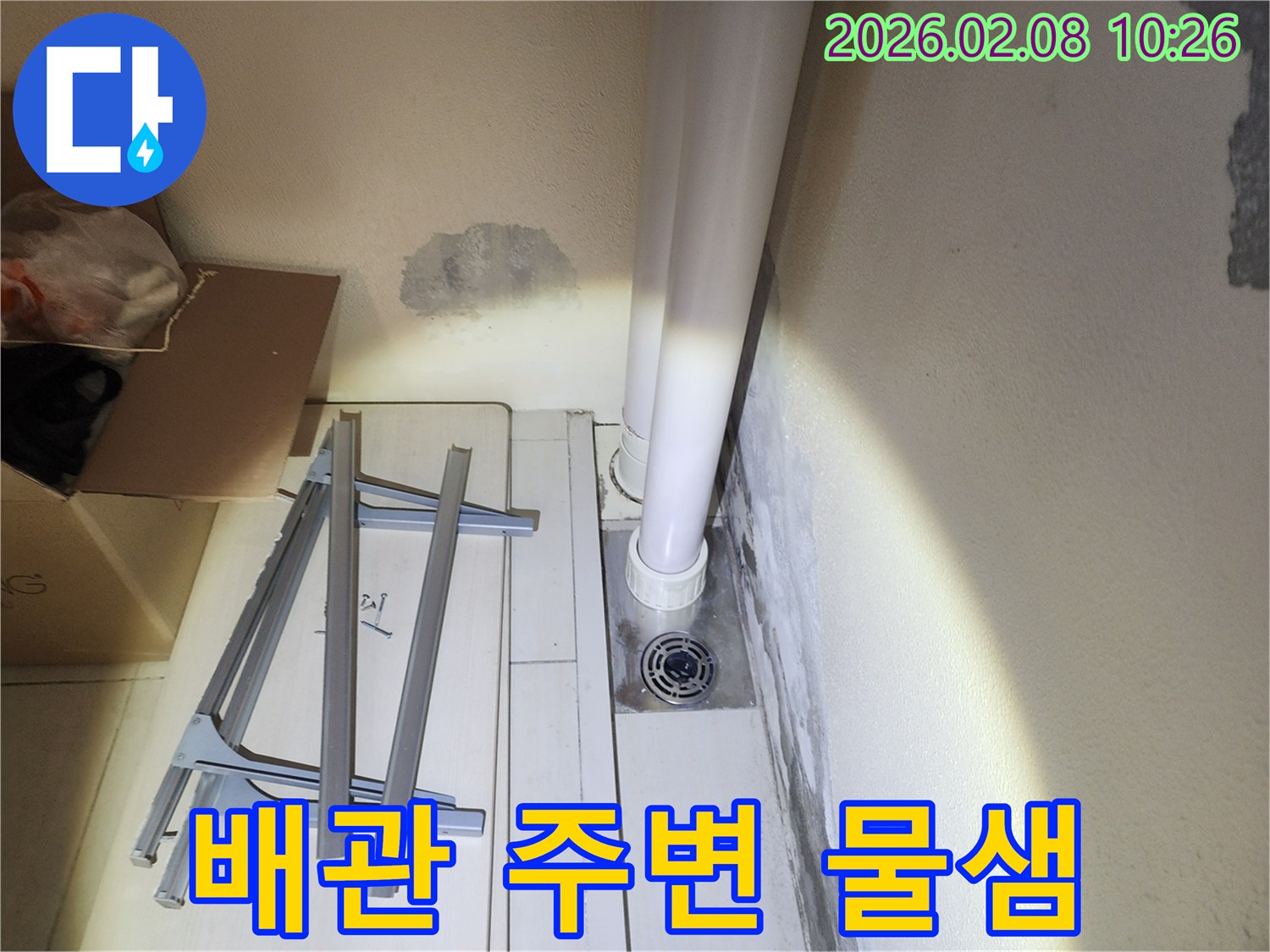 오래된 배관 주변에서 발생한-누수로 인해-벽면이 젖고 곰팡이가 시작된-상황을 보여줍니다.