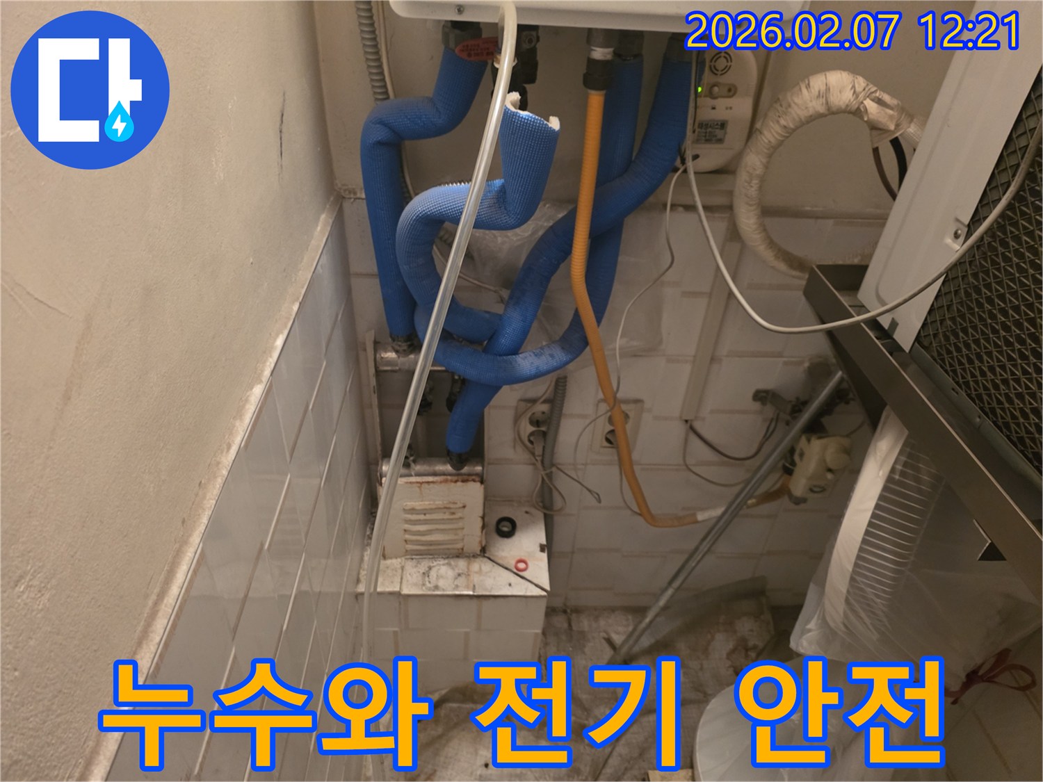 보일러실 배관 누수 점검 중-주변 전기 콘센트와 배선의-안전 상태를 함께 확인하는-책임감 있는 모습입니다.