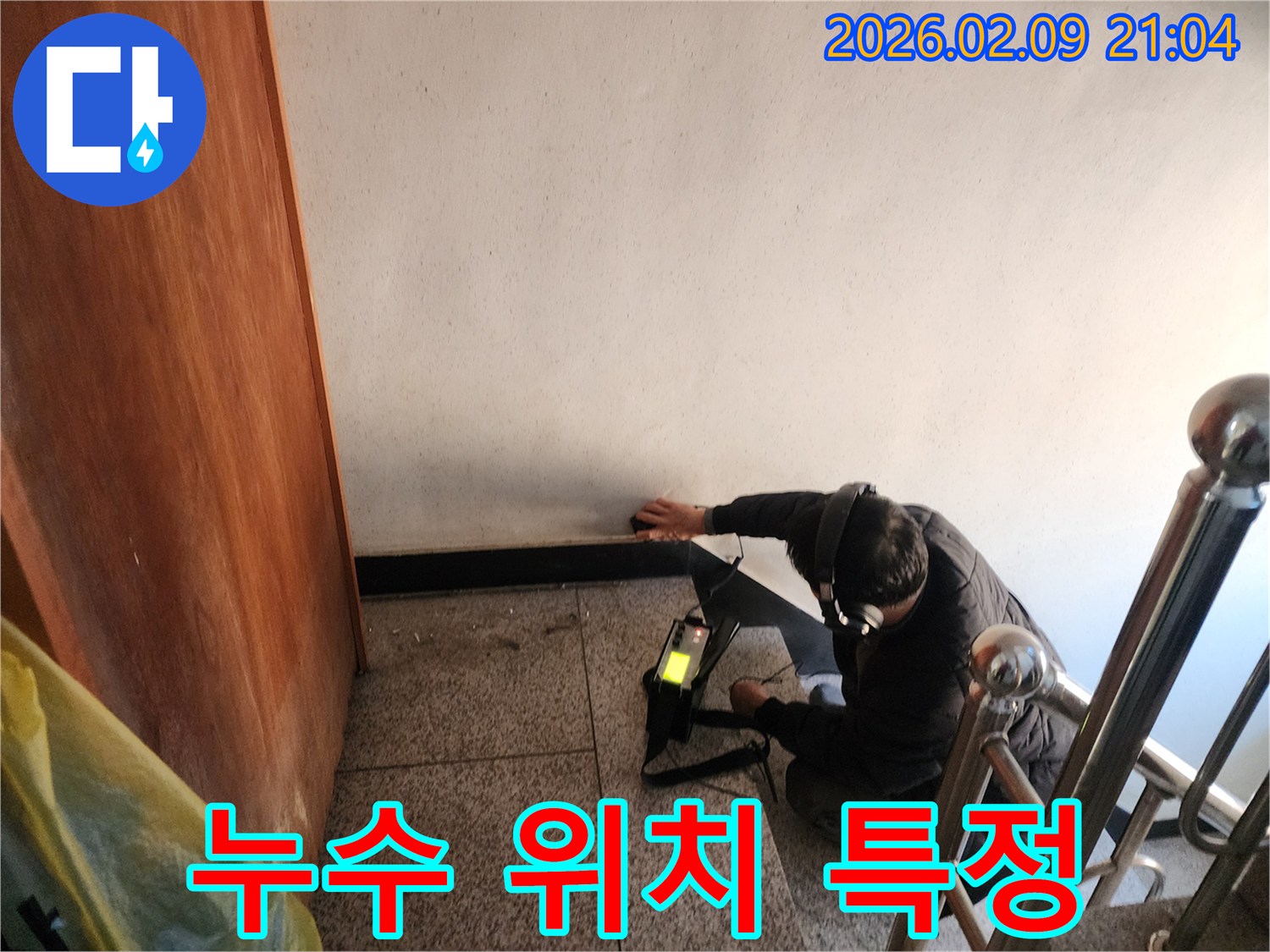 전문-기술자가-누수-탐지기를-사용하여-건물-내부의-미세한-물샘-소리를-집중적으로-듣고-있는-장면