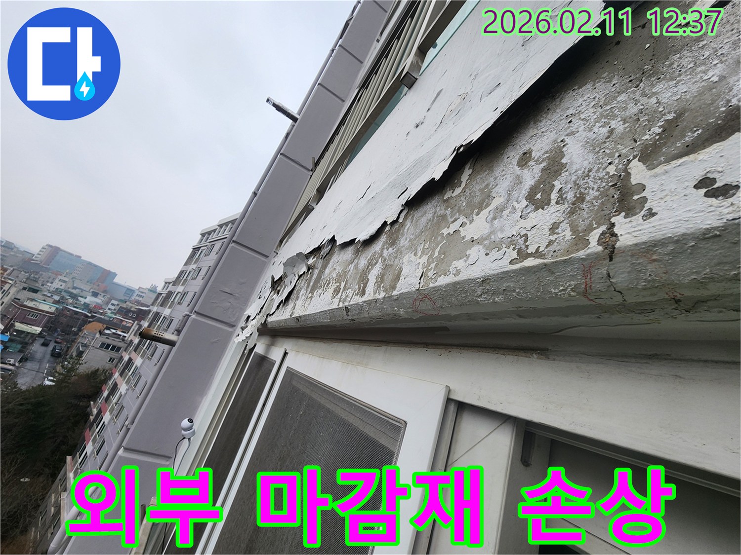 상가 건물 외벽의 마감재가 손상되어-페인트가 벗겨지고-누수 발생 가능성이 높은 상태