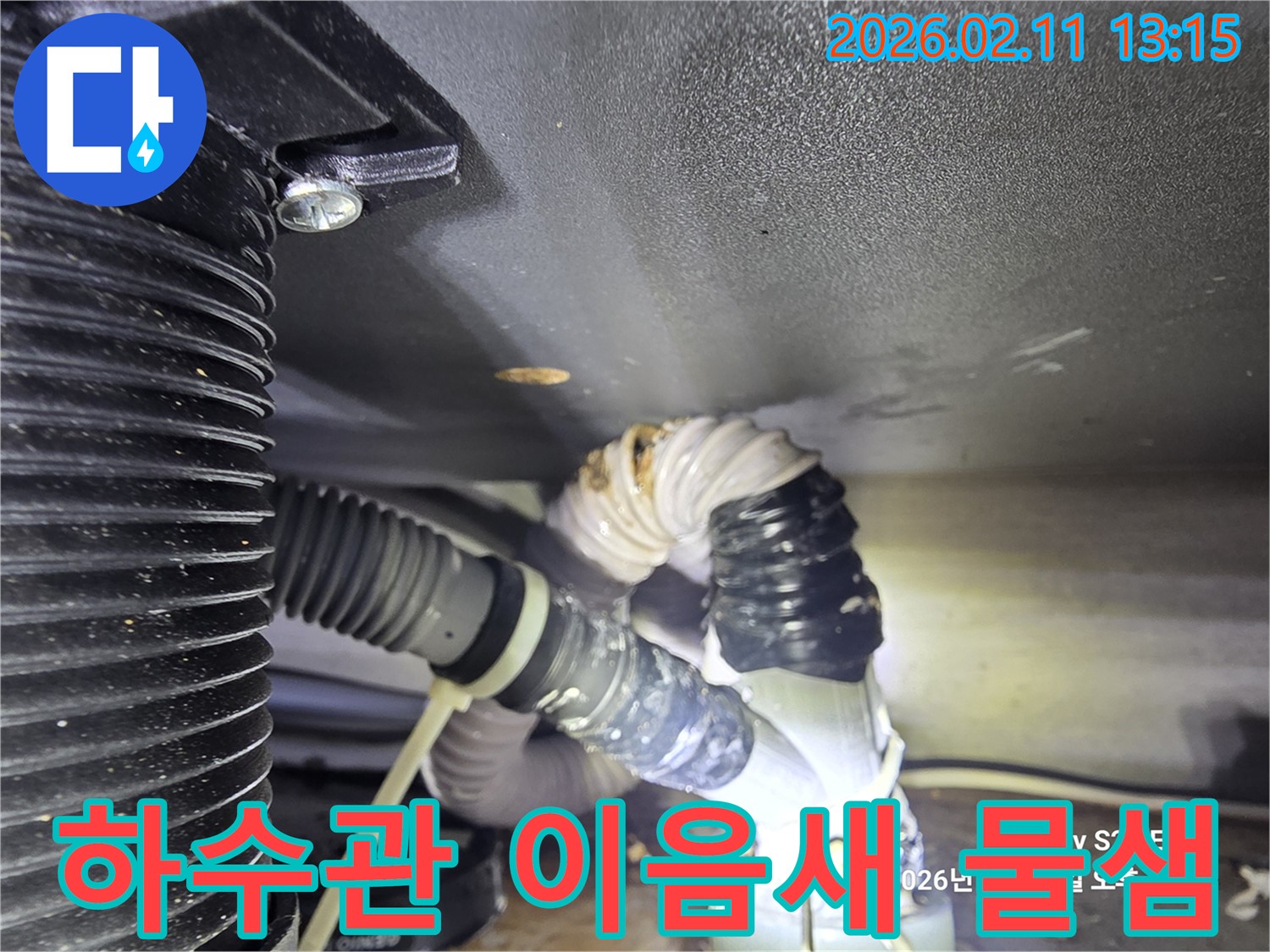하수관의 이음새 부분에서 물이 새는 현장을 찍은 사진입니다-주변에 물기가 흥건하게 고여 있습니다
